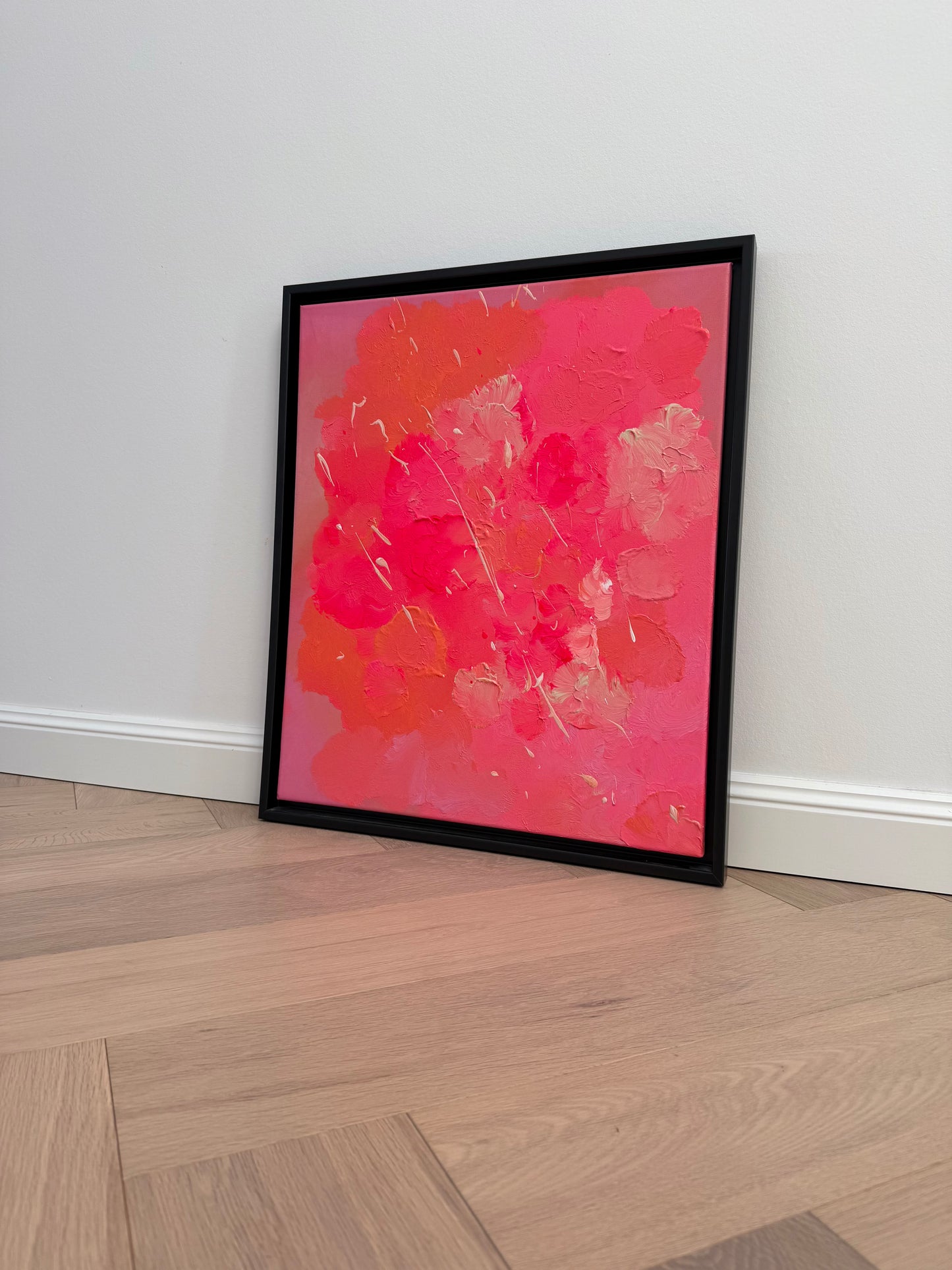 Abstraktes gerahmtes Kunstwerk „FLORALS #2“ in Pink und Orange auf hellem Holzparkett inszeniert, moderne Wandkunst mit fein glänzender Oberfläche vor weißer Wand