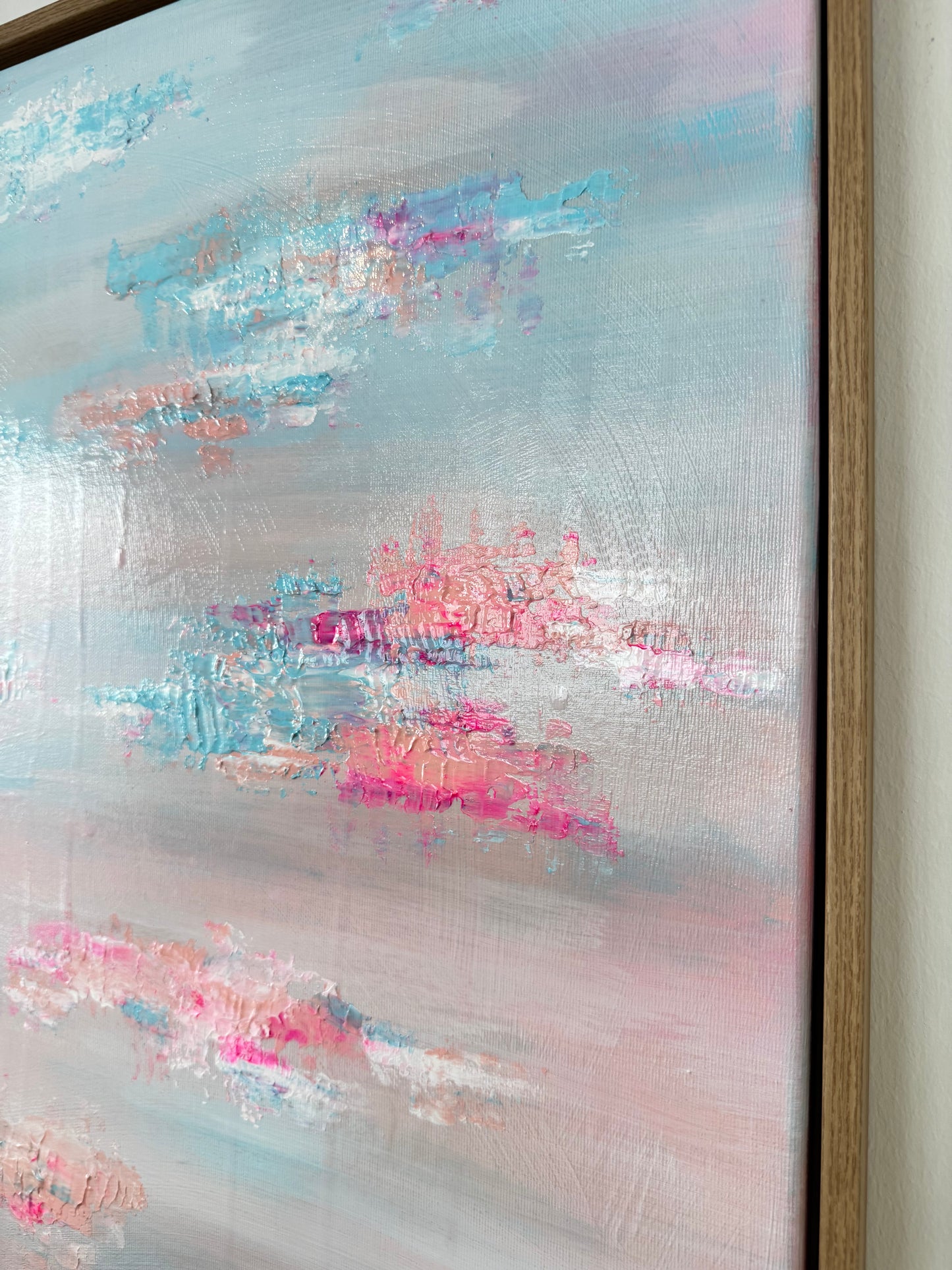 Nahaufnahme der strukturierten und glänzenden Oberfläche von abstraktem Acrylbild in Pastell Blau Rosa mit sichtbarer Textur und Lichtreflexion