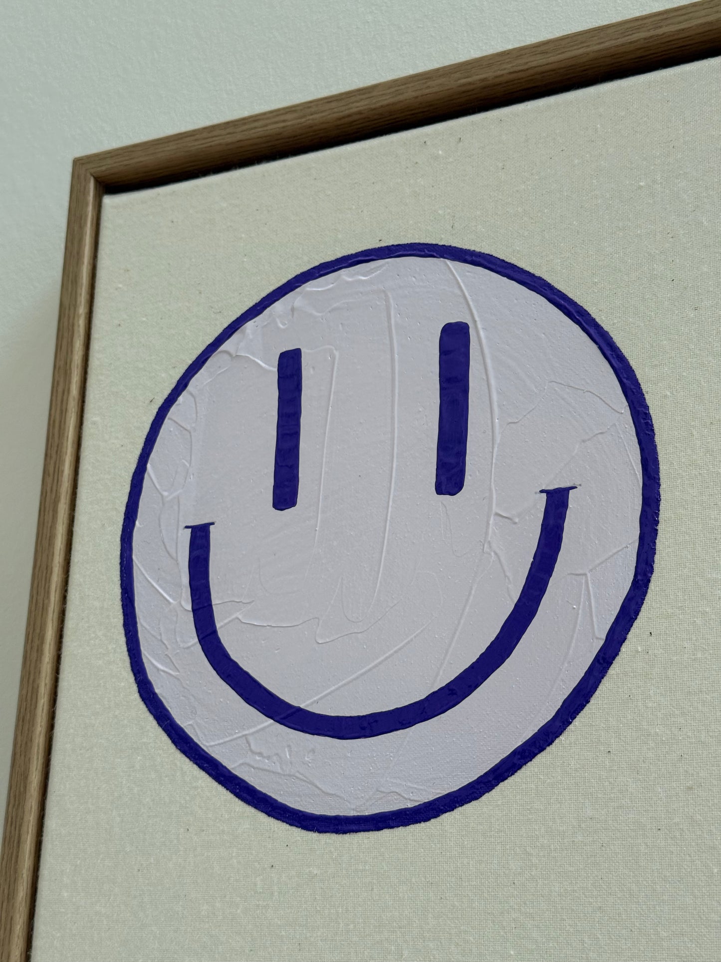 Makroaufnahme des fliederfarbenen Happy-Faces von HAPPY #19 auf roher Leinwand, mit strukturierter Acryloberfläche und hochwertigem Schattenfugenrahmen.
