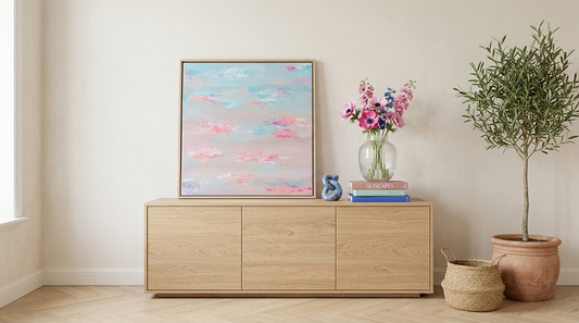 Abstraktes Acrylbild in Pastell Blau und Rosa auf Sideboard im Wohnzimmer, moderne Wandkunst mit sanften Farbverläufen und ruhiger Atmosphäre