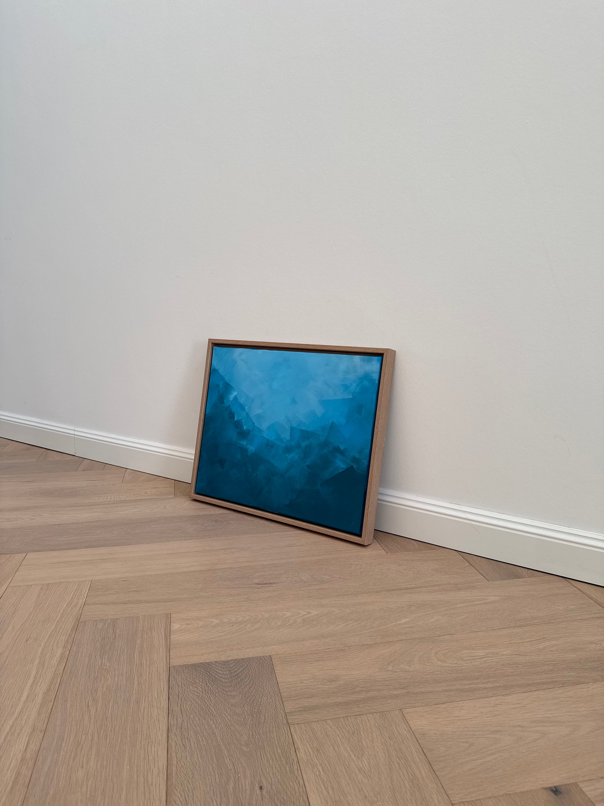 Ruhiges abstraktes Acrylgemälde in Blautönen, gerahmt in Holz, mit klarer, minimalistischer Raumwirkung.