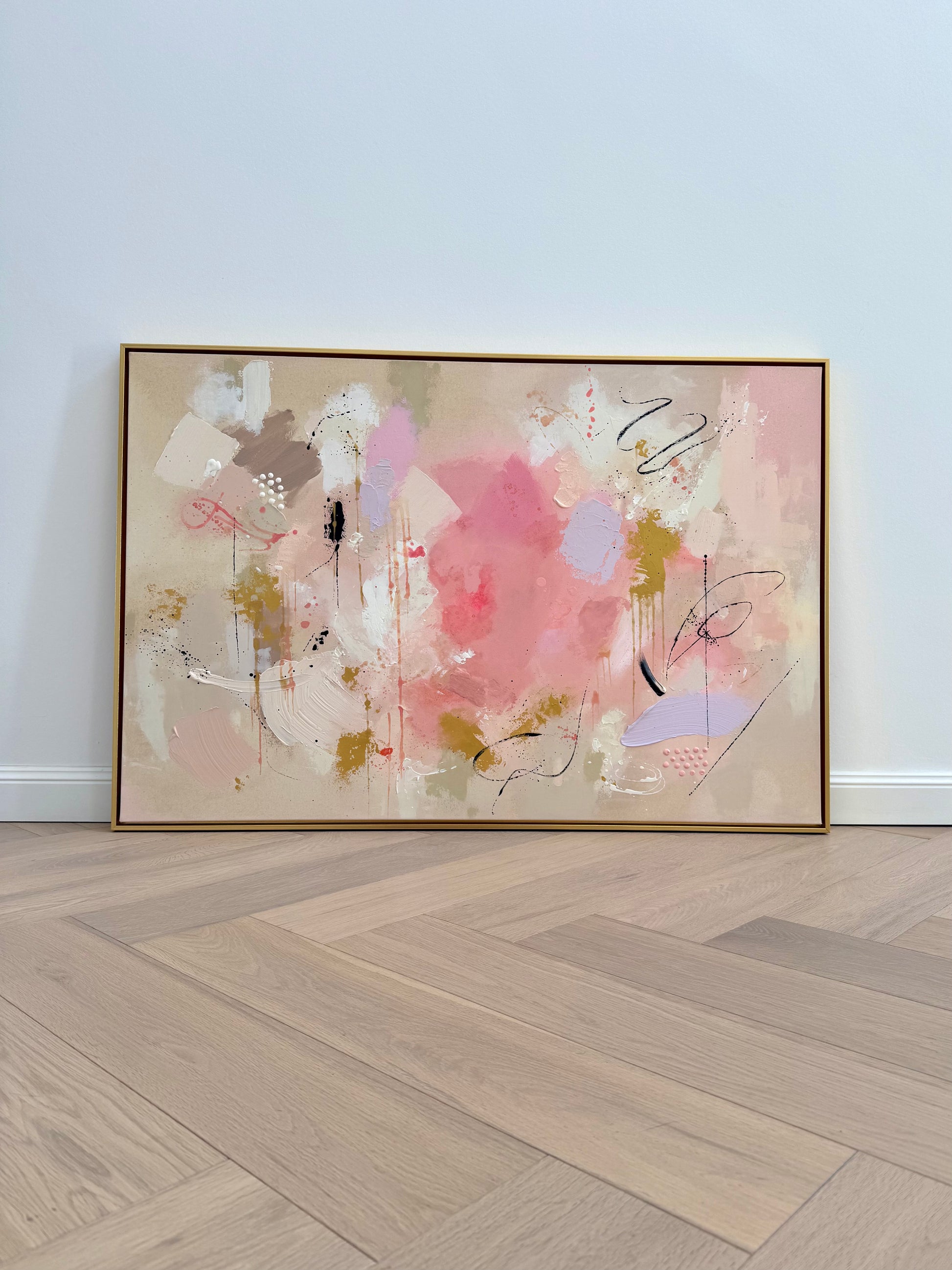 Abstraktes Wandbild CARE FOR YOUR SOUL aus der TRACES SERIES in Beige, Champagner, Altrosa, Hellrosa, Flieder, Gold und Schwarz, handgemalt mit Acryl und feiner Strukturpaste auf Leinwand, gerahmt im goldenen Schattenfugenrahmen als modernes Statement Piece für helle Interior-Räume.