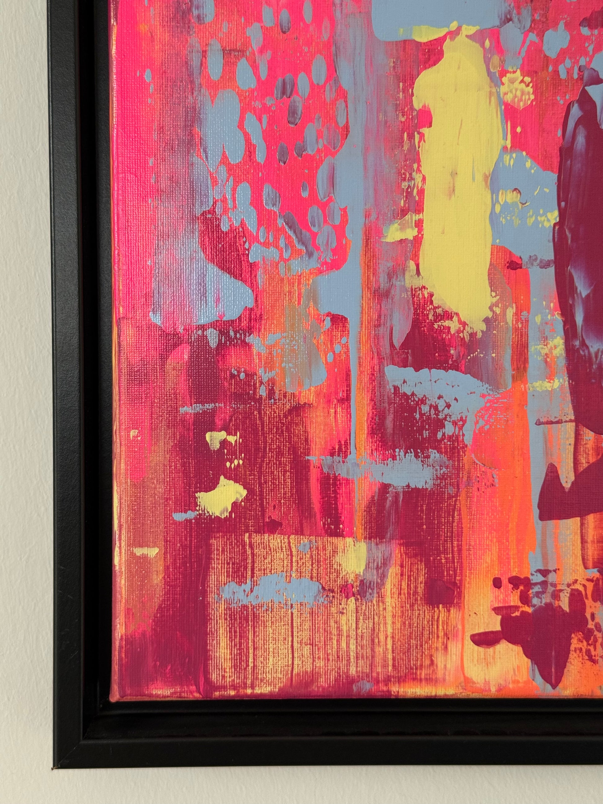 Detailaufnahme des abstrakten Originalkunstwerks „EVOLVING“, Acryl auf Leinwand mit sichtbarer Textur in Pink, Blau, Gelb und Orange, schwarzer Rahmen