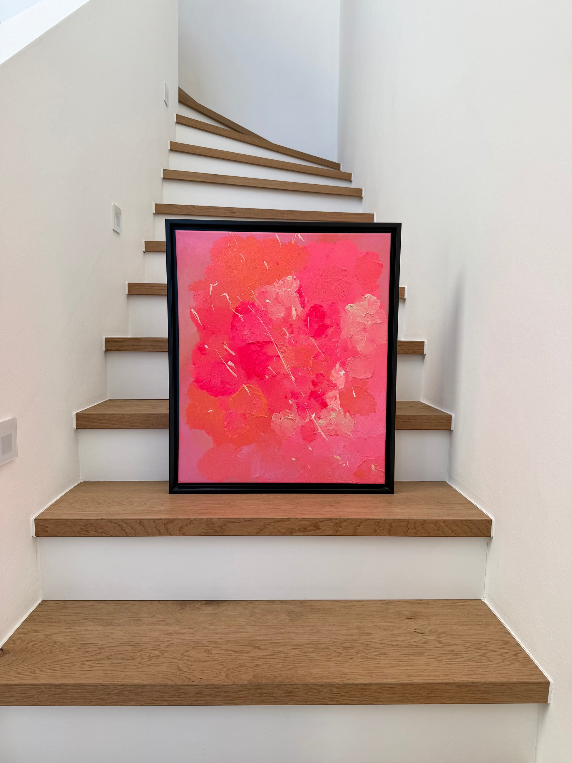 Abstraktes Kunstwerk „FLORALS #2“ in Pink und Orange, gerahmt, auf einer Holztreppe inszeniert, moderne Wandkunst mit strukturierter, glänzender Oberfläche