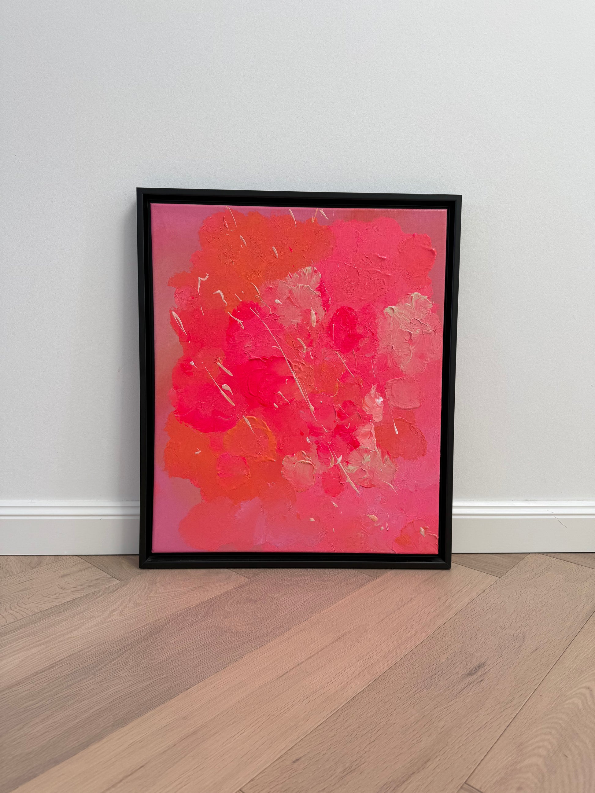 Abstraktes Originalkunstwerk „FLORALS #2“ in Pink und Orange mit glänzender, strukturierter Oberfläche, gerahmt vor heller Wand