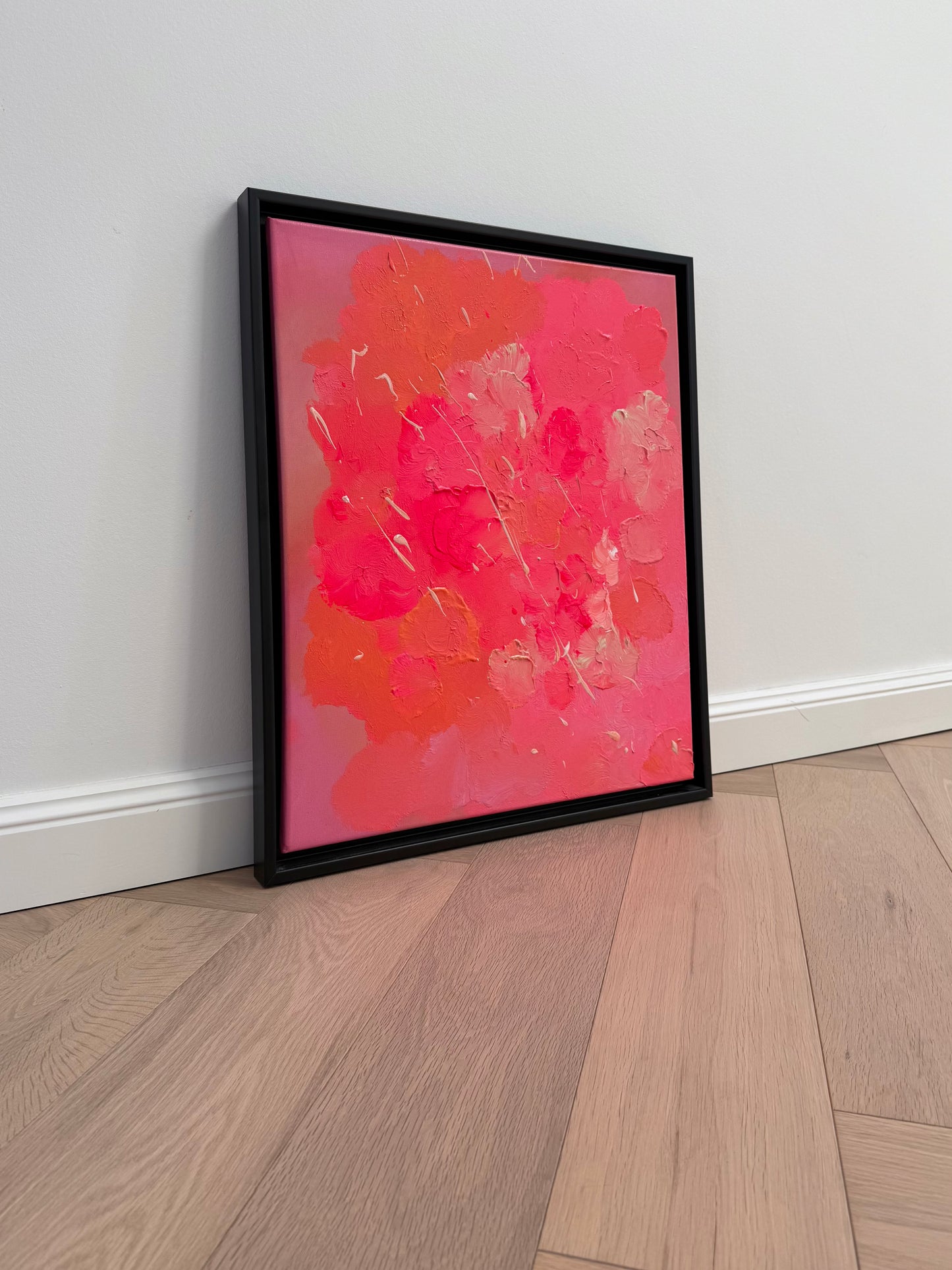 Pinke abstrakte Kunst auf Leinwand mit sichtbarer Textur und Glanz, seitliche Detailansicht eines handgemalten Acrylbildes im schwarzen Rahmen