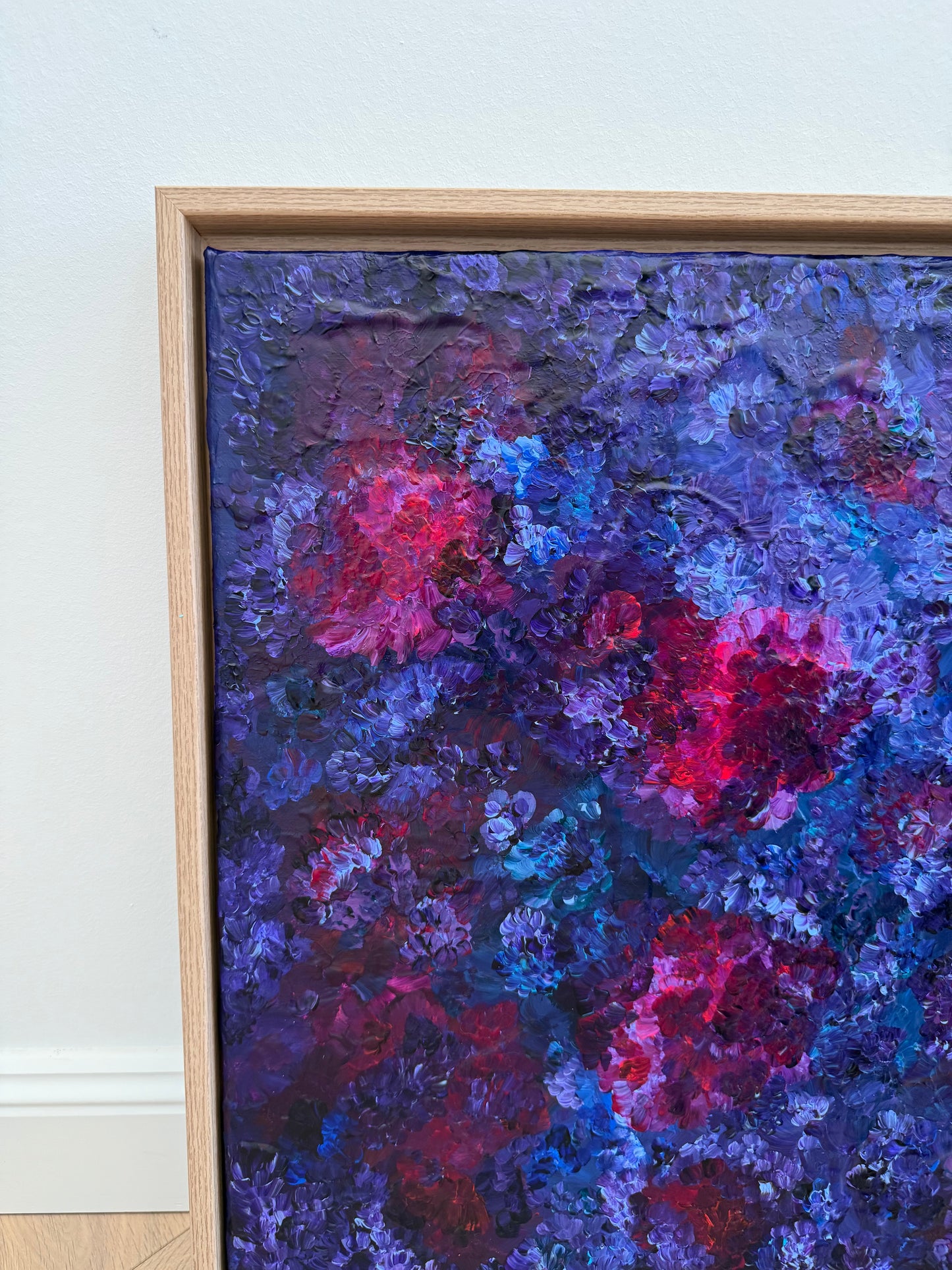 Nahaufnahme eines abstrakten floralen Acrylkunstwerks mit starker Textur in Violett und Blau, leuchtende Magenta-Akzente