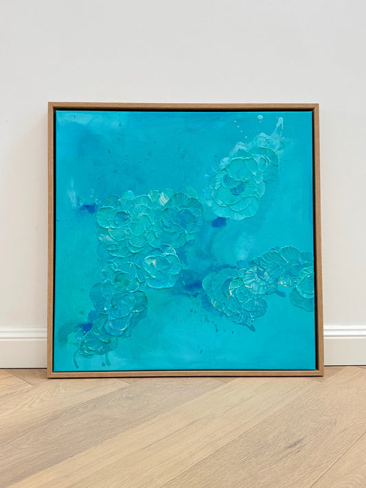 FLORALS #12, handgemaltes abstraktes Acrylbild in Türkis und Blau, 60x60 cm, moderne florale Wandkunst mit organischer Bewegung und sichtbarer Textur, gerahmt in Eiche, ruhige Inszenierung vor neutraler Wand und hellem Holzfußboden