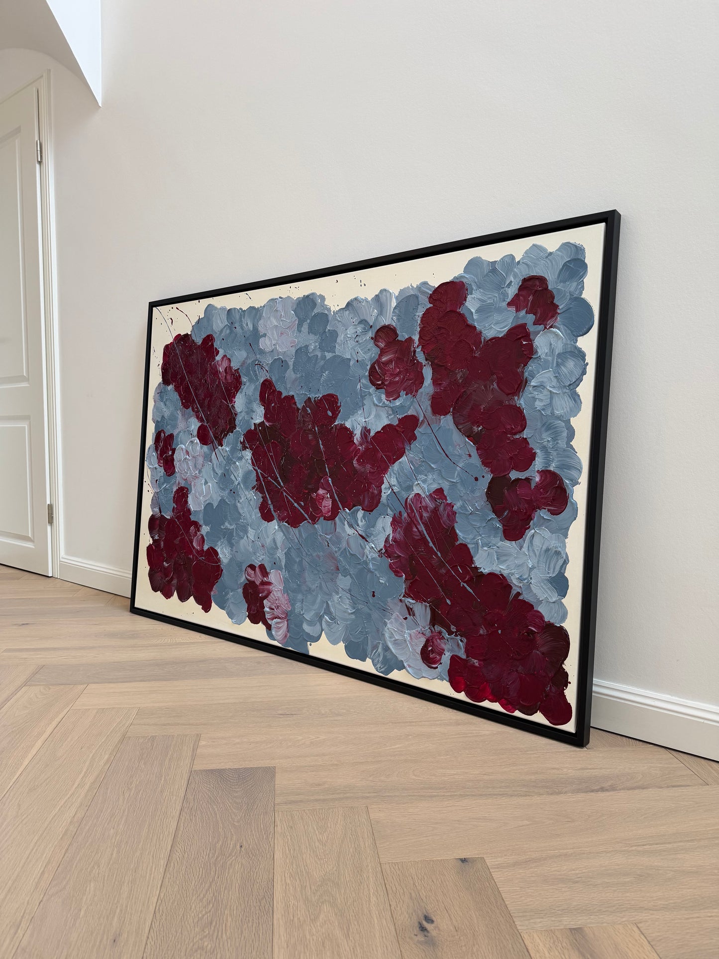 FLORALS #14 als großformatiges florales Acrylbild im schwarzen Rahmen, fotografiert seitlich im hellen Eingangsbereich