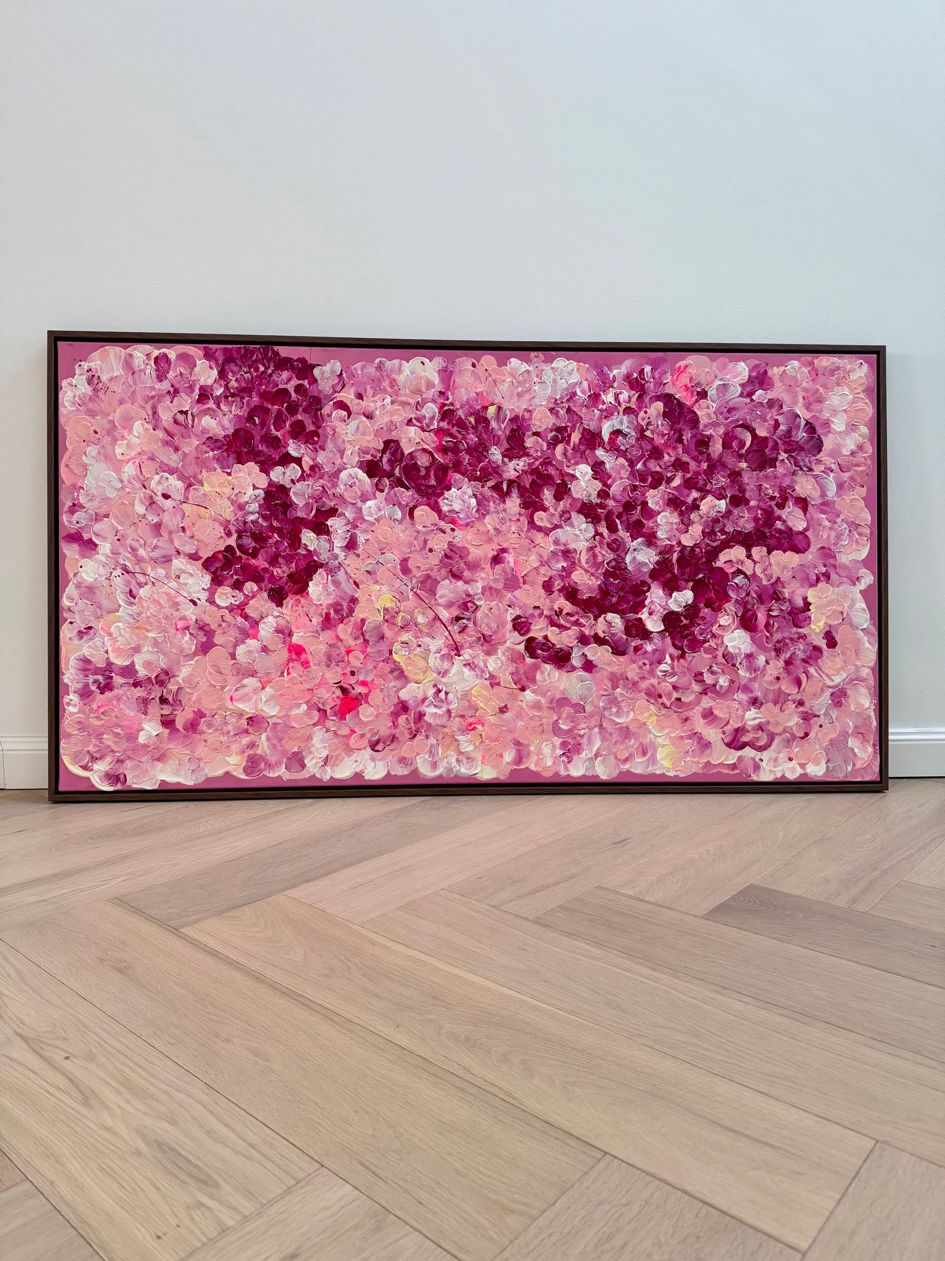 FLORALS #15 von Sophia Toschka, modernes abstrakt-florales Acrylbild in Rosa, Pink, Bordeaux und Creme, 150x80 cm auf Leinwand mit sichtbarer Textur und dunkelbraunem Schattenfugenrahmen, fotografiert im minimalistischen Interior.