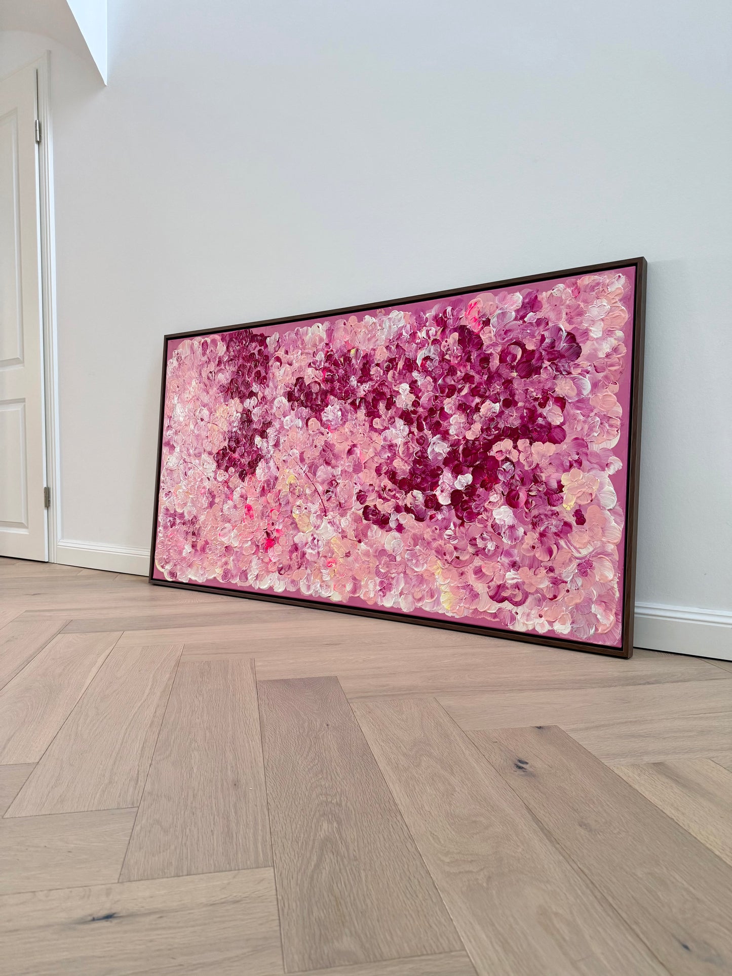 FLORALS #15 von Sophia Toschka, großes abstrakt-florales Acrylbild in Rosa, Pink, Creme und Bordeaux, 150x80 cm mit sichtbarer Textur und dunkelbraunem Schattenfugenrahmen, fotografiert in modernem minimalistischem Wohnraum.