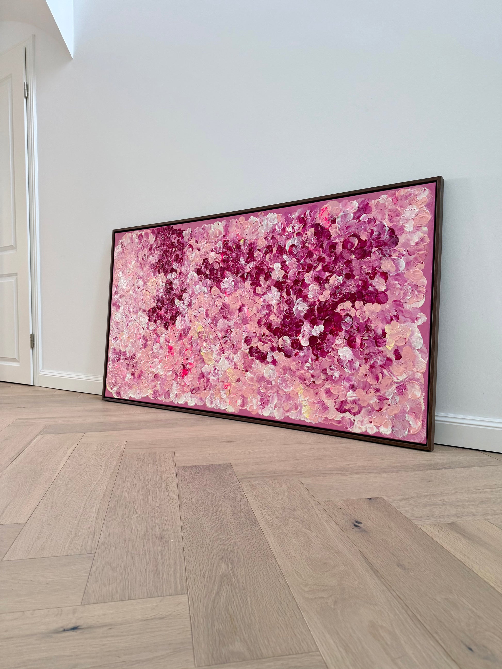 FLORALS #15 von Sophia Toschka, großes abstrakt-florales Acrylbild in Rosa, Pink, Creme und Bordeaux, 150x80 cm mit sichtbarer Textur und dunkelbraunem Schattenfugenrahmen, fotografiert in modernem minimalistischem Wohnraum.