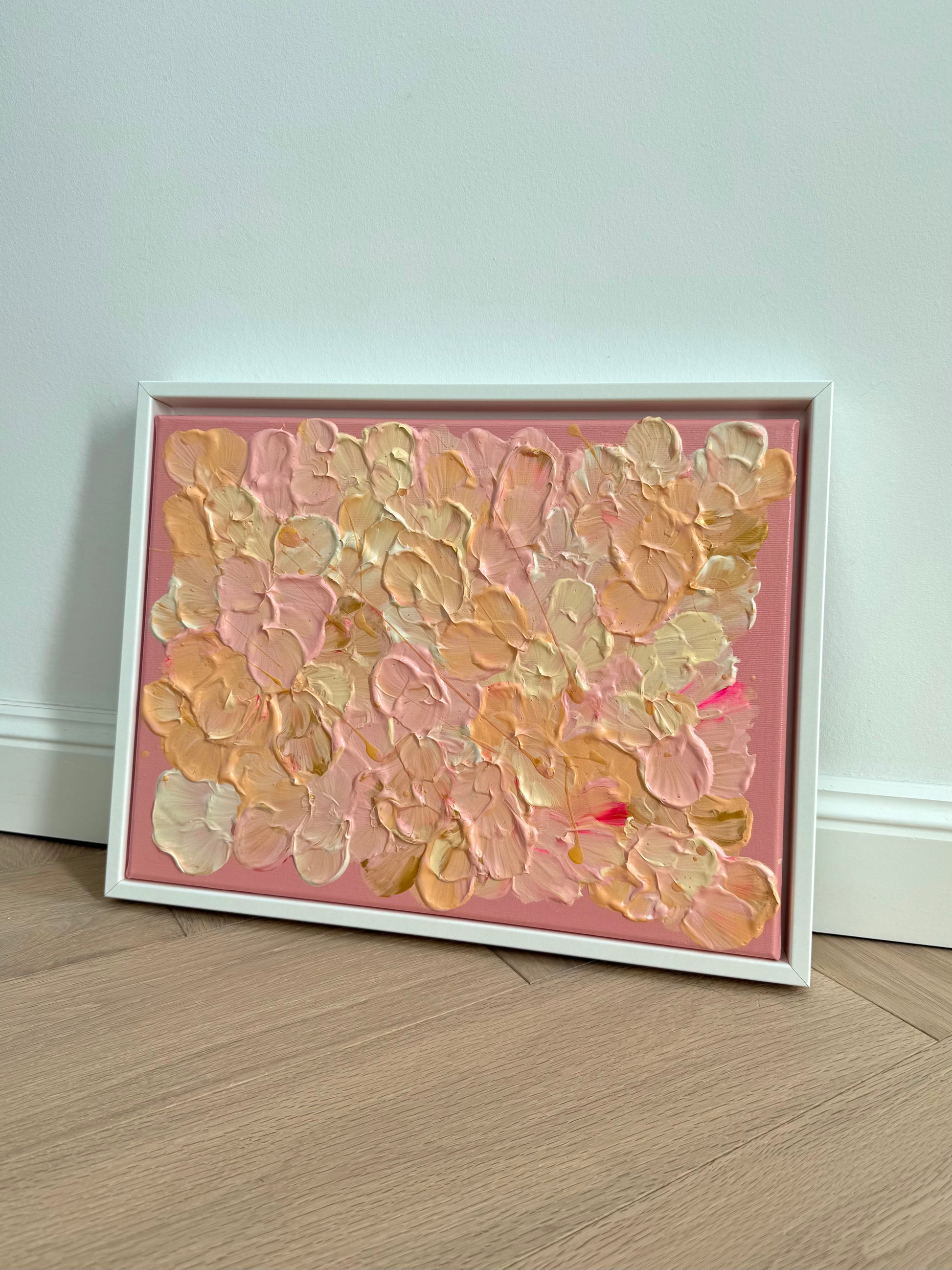 FLORALS #19 schräg aufgestellt vor heller Wand, kleines florales Originalkunstwerk in warmen Pastelltönen mit weißem Schattenfugenrahmen.