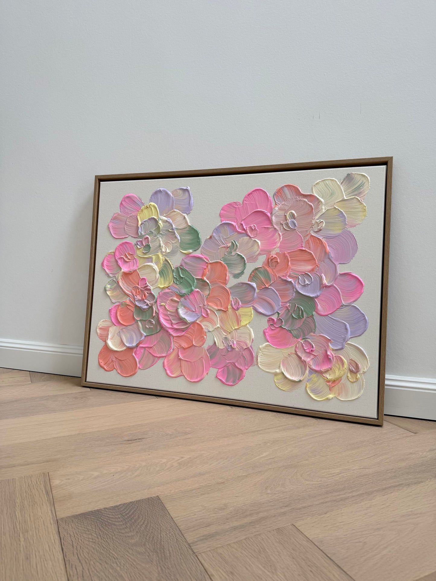 Florale Strukturkunst auf roher Leinwand mit plastischen Blüten, zarten Pastellfarben und natürlichem Schattenfugenrahmen.
