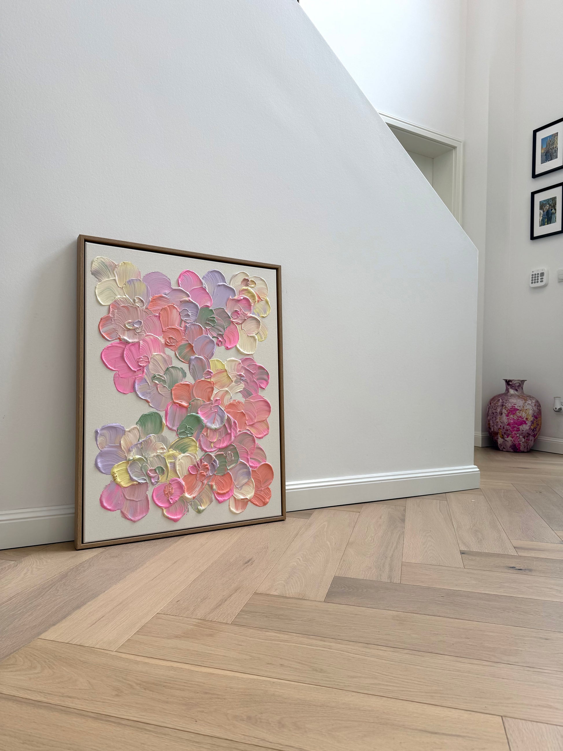 Modernes florales Wandbild mit strukturierter Acrylfarbe, roher Leinwand und weichen Pastelltönen in Pink, Salbei und Hellgelb.