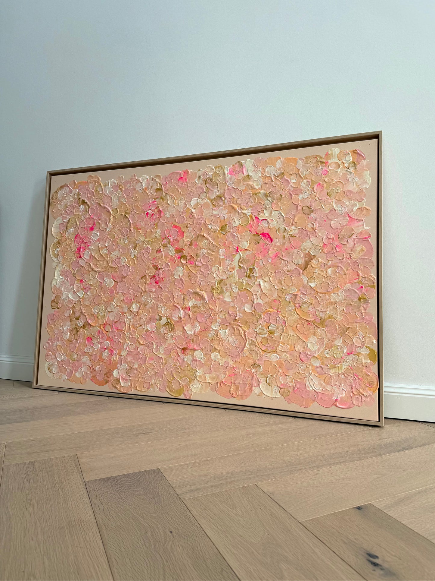 Großformatiges Acrylbild FLORALS #21 im hellen Interior, angelehnt an eine weiße Wand, mit floraler Textur in Rosa, Apricot und Creme.