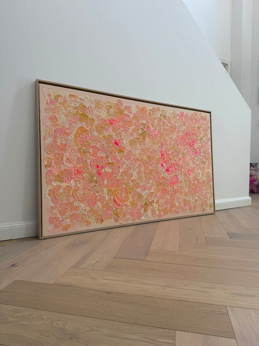 Großformatiges Auftragskunstwerk FLORALS #23 von Sophia Toschka, 150 × 90 cm, angelehnt an eine helle Wand auf Holzboden, mit floraler Struktur in Rosa, Apricot, Creme und Neonpink im hellen Holzrahmen.