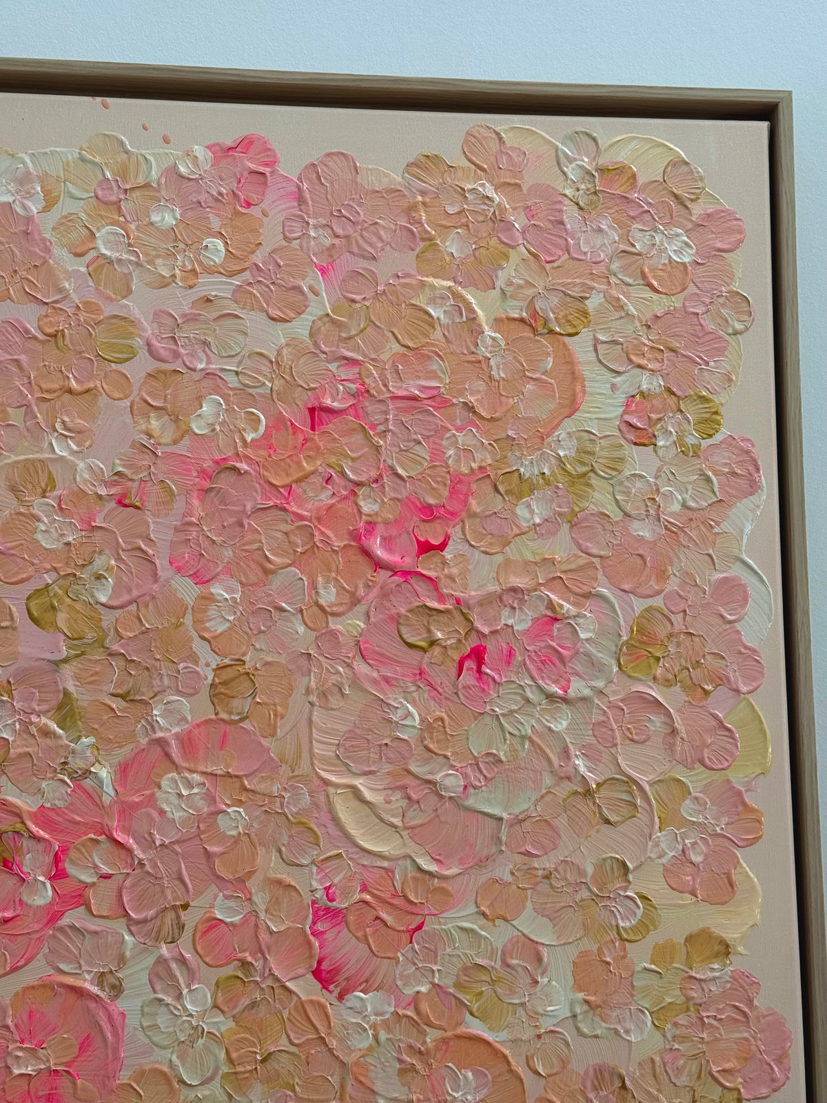 Schräge Detailansicht von FLORALS #23 mit strukturierter floraler Komposition in warmen Rosa-, Apricot- und Cremetönen sowie hellem Schattenfugenrahmen aus Holz.