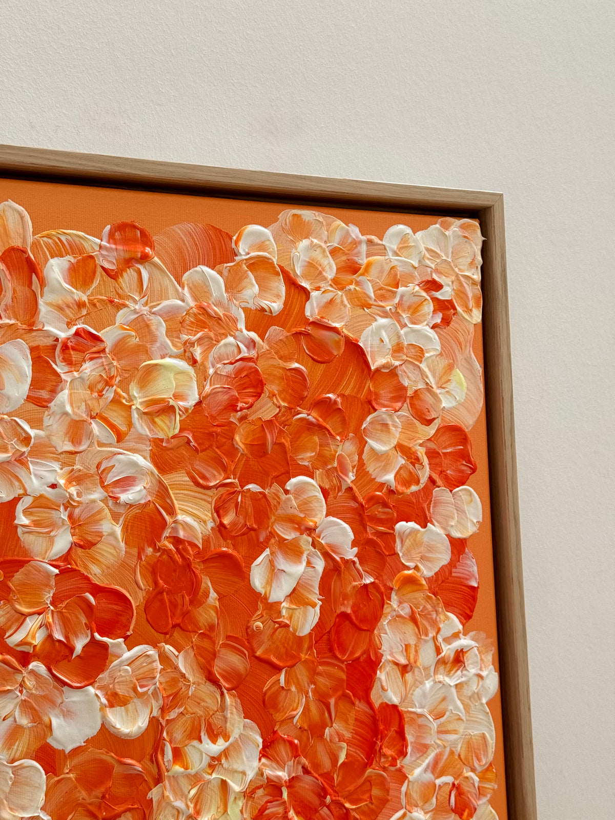 Obere rechte Ecke von FLORALS #25 mit erhabenen orangenen und cremeweißen Blütenformen auf orangefarbenem Hintergrund, gerahmt im hellen Eichenrahmen.