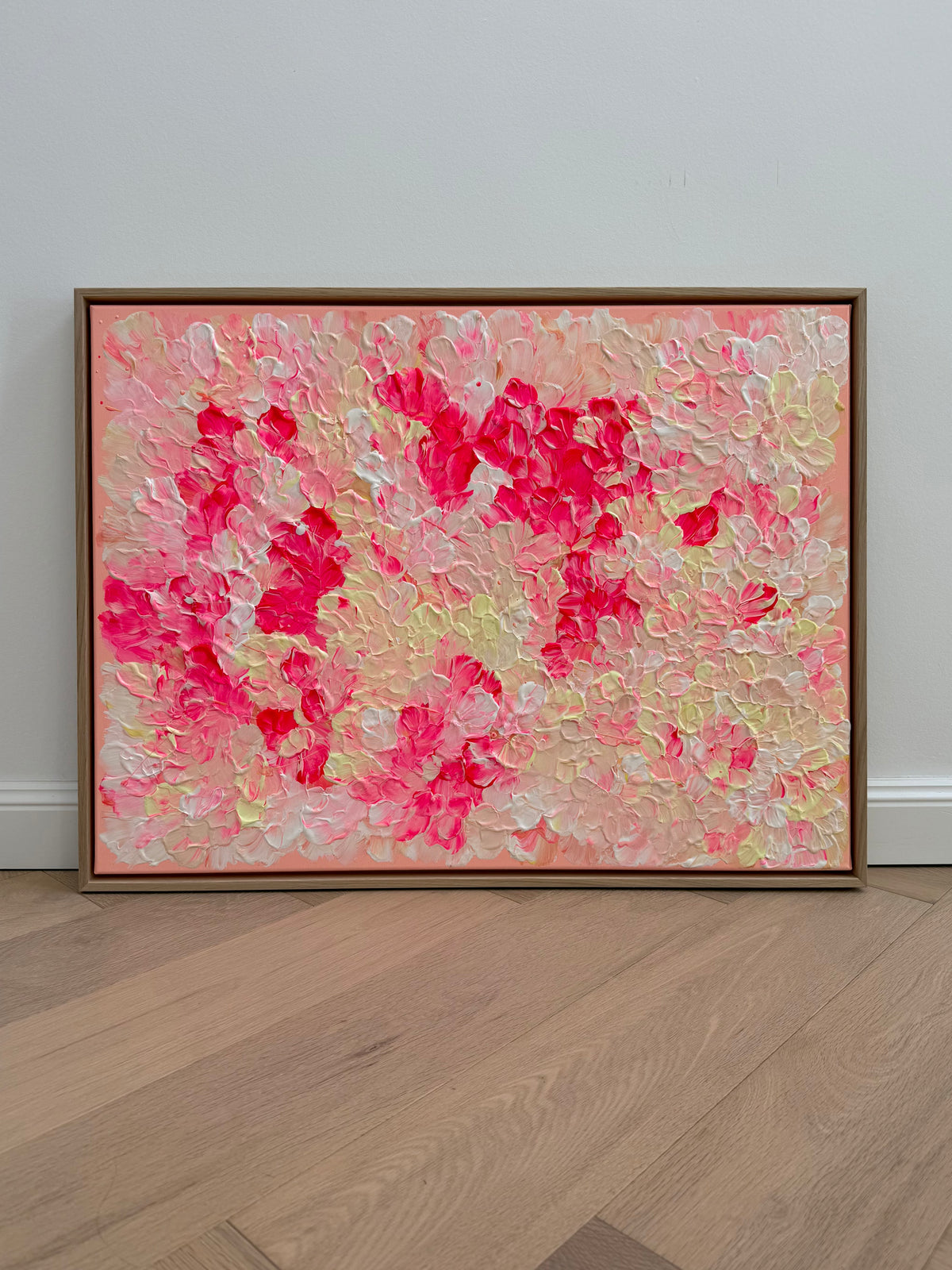 Frontansicht von FLORALS #26 im Querformat mit leuchtenden pinken Blütengruppen, hellen Zwischenpartien und umlaufendem Schattenfugenrahmen aus Eiche Natur.