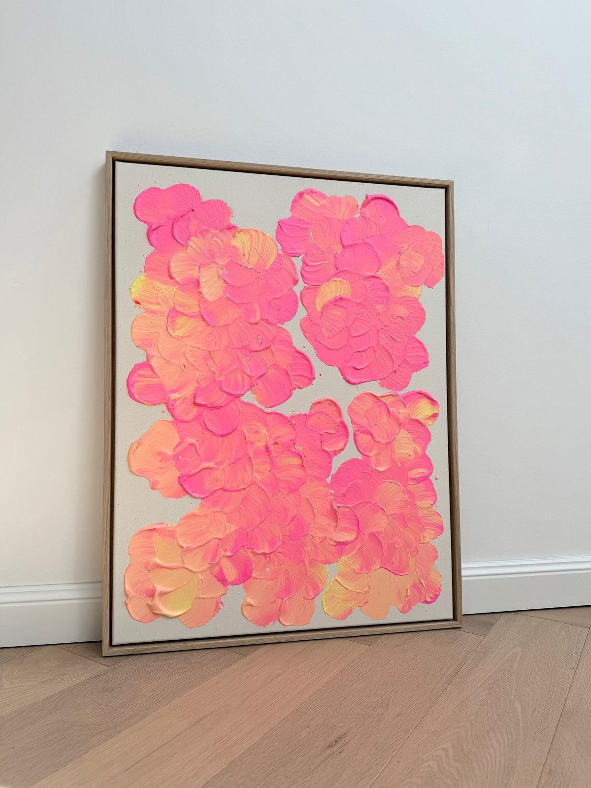FLORALS #27, florales Acrylbild in Neonpink, Lachsorange und Hellgelb auf roher Leinwand, 60 × 80 cm, im hellen Eichenrahmen.