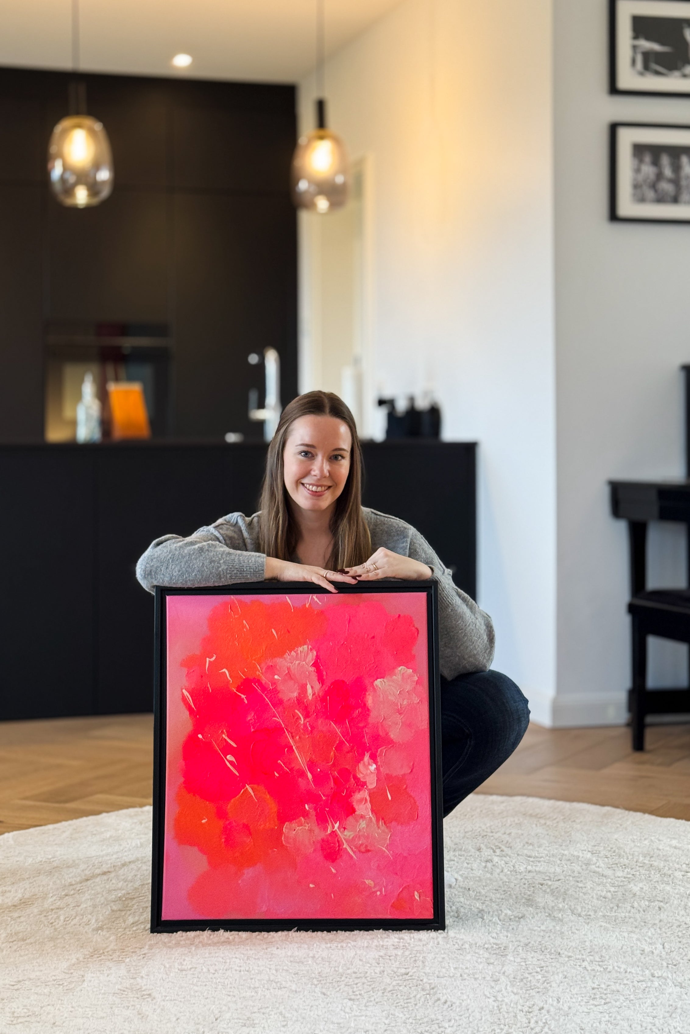 Abstraktes Kunstwerk in Pink- und Orangetönen, präsentiert in einem Wohnraum mit moderner Einrichtung.