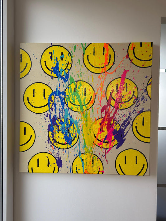 Abstraktes Happy-Face-Acrylbild mit Regenbogen-Farbspritzern auf hellem Hintergrund, moderne Wandkunst mit Struktur in lichtdurchflutetem Raum