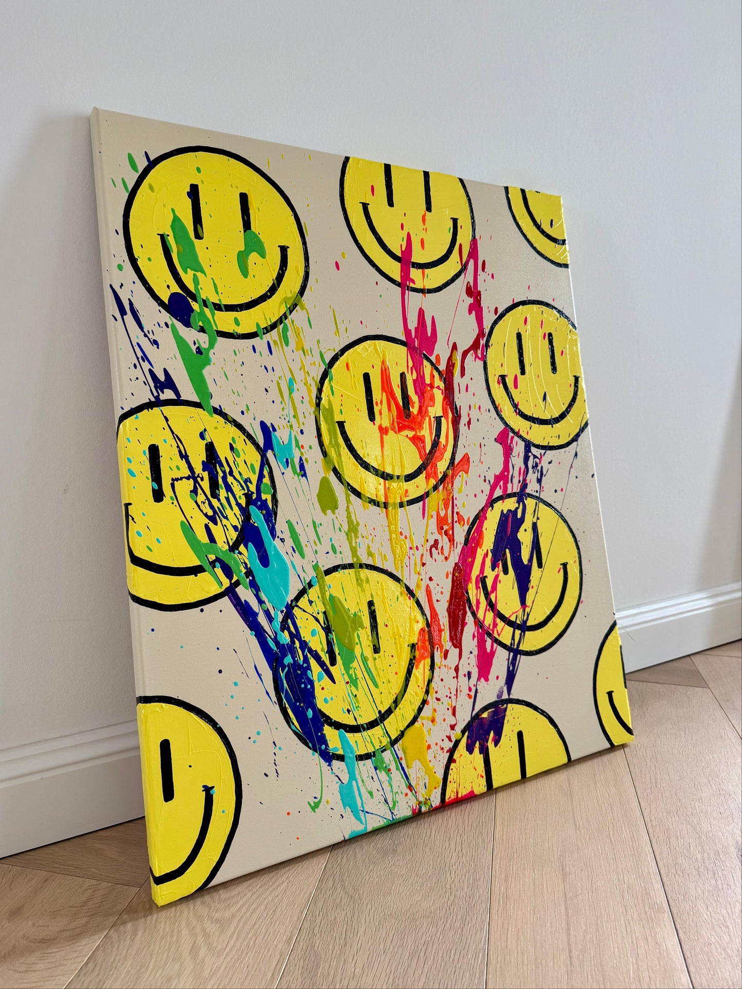 HAPPY #11 modernes Acrylbild mit bunten Farbspritzern und Happy-Faces, leicht seitlich fotografiert auf Leinwand.