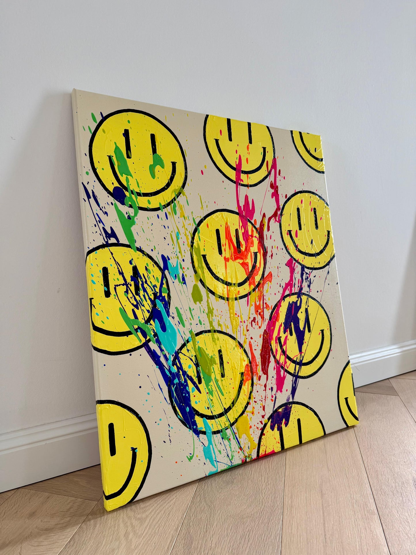 HAPPY #11 modernes Acrylbild mit bunten Farbspritzern und Smileys, leicht seitlich fotografiert auf Leinwand.