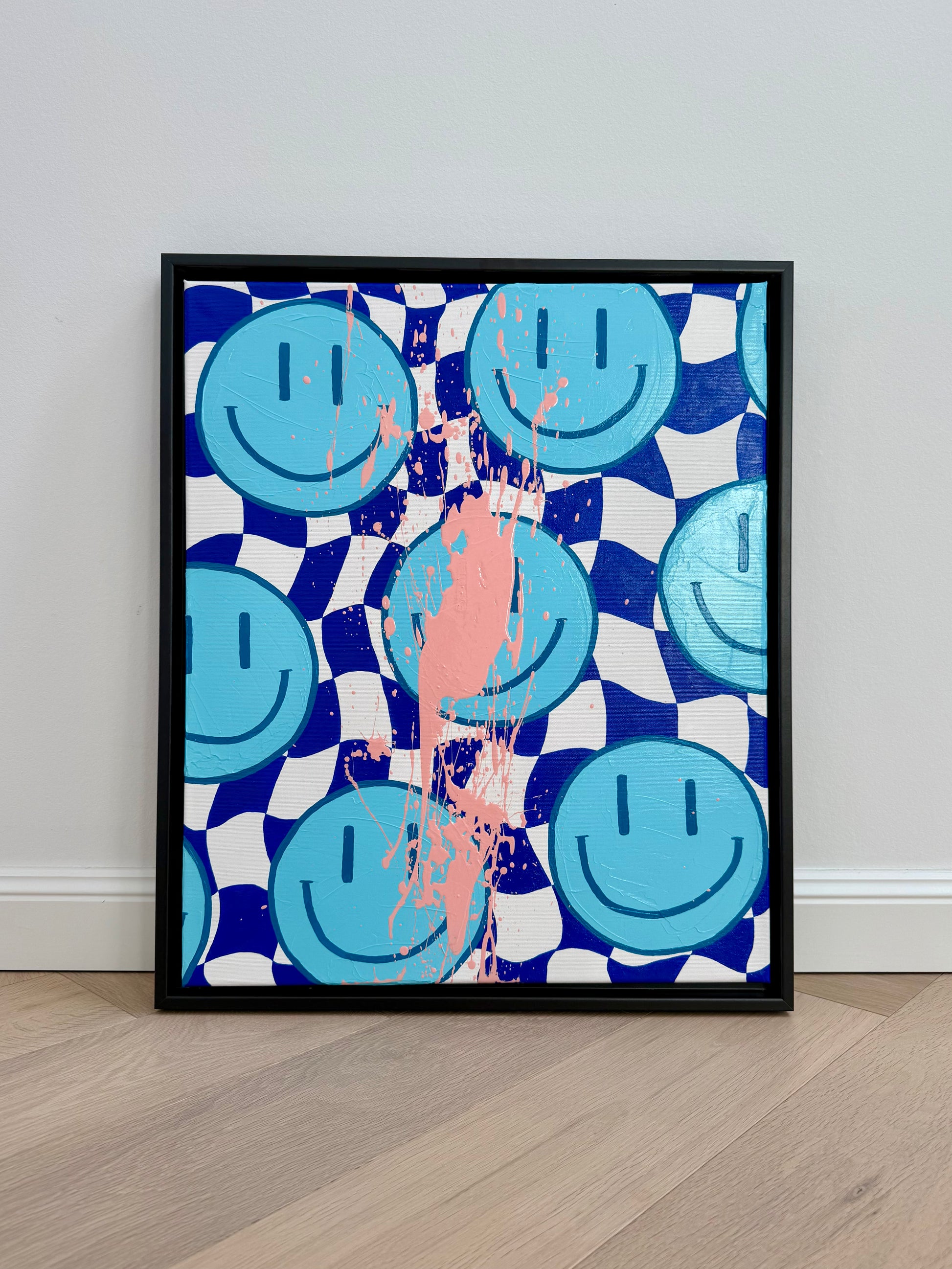 HAPPY #13 von Sophia Toschka – modernes Happy-Face Acrylbild in Blau, Weiß und Rosa mit schwarzem Schattenfugenrahmen, Schachbrettmuster und sichtbarer Textur
