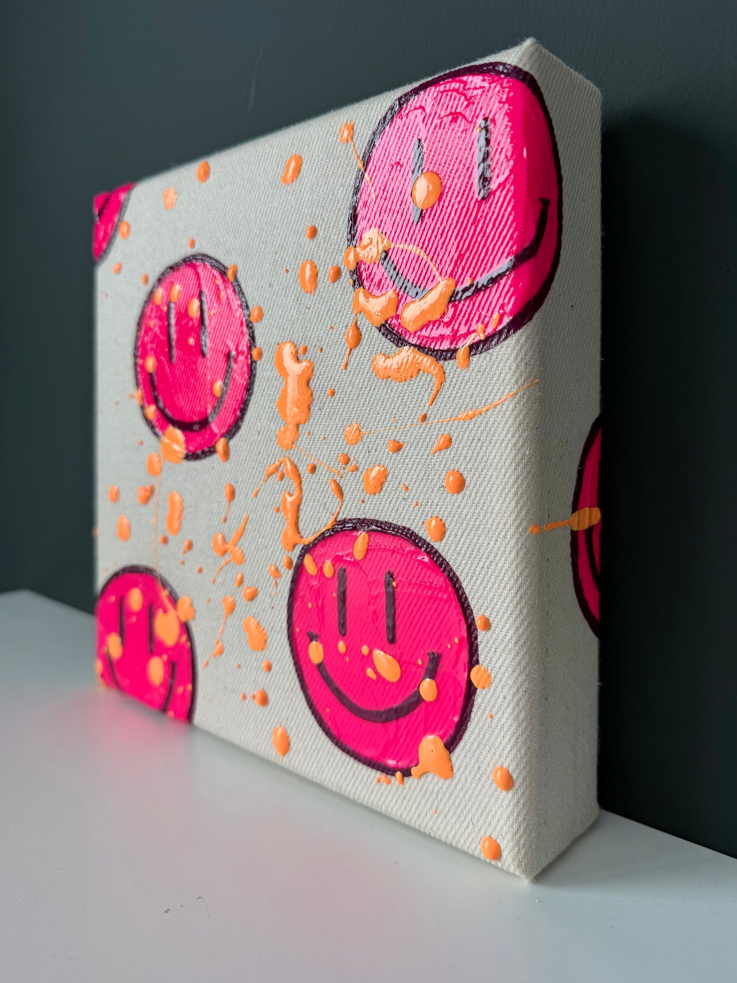 Seitliche Perspektive des Happy-Face-Acrylbilds „HAPPY #14“ mit sichtbarer Leinwandstruktur und Farbspritzern – modernes Kunstwerk auf Leinwand