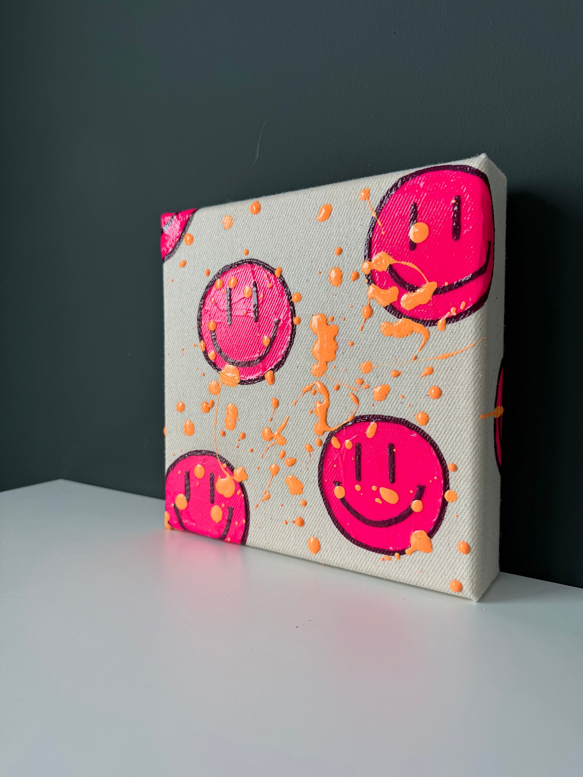 Modernes Neonpink Happy-Face-Kunstwerk „HAPPY #14“ auf Sideboard – kleines Acrylbild als Dopamine Decor für moderne Interiors