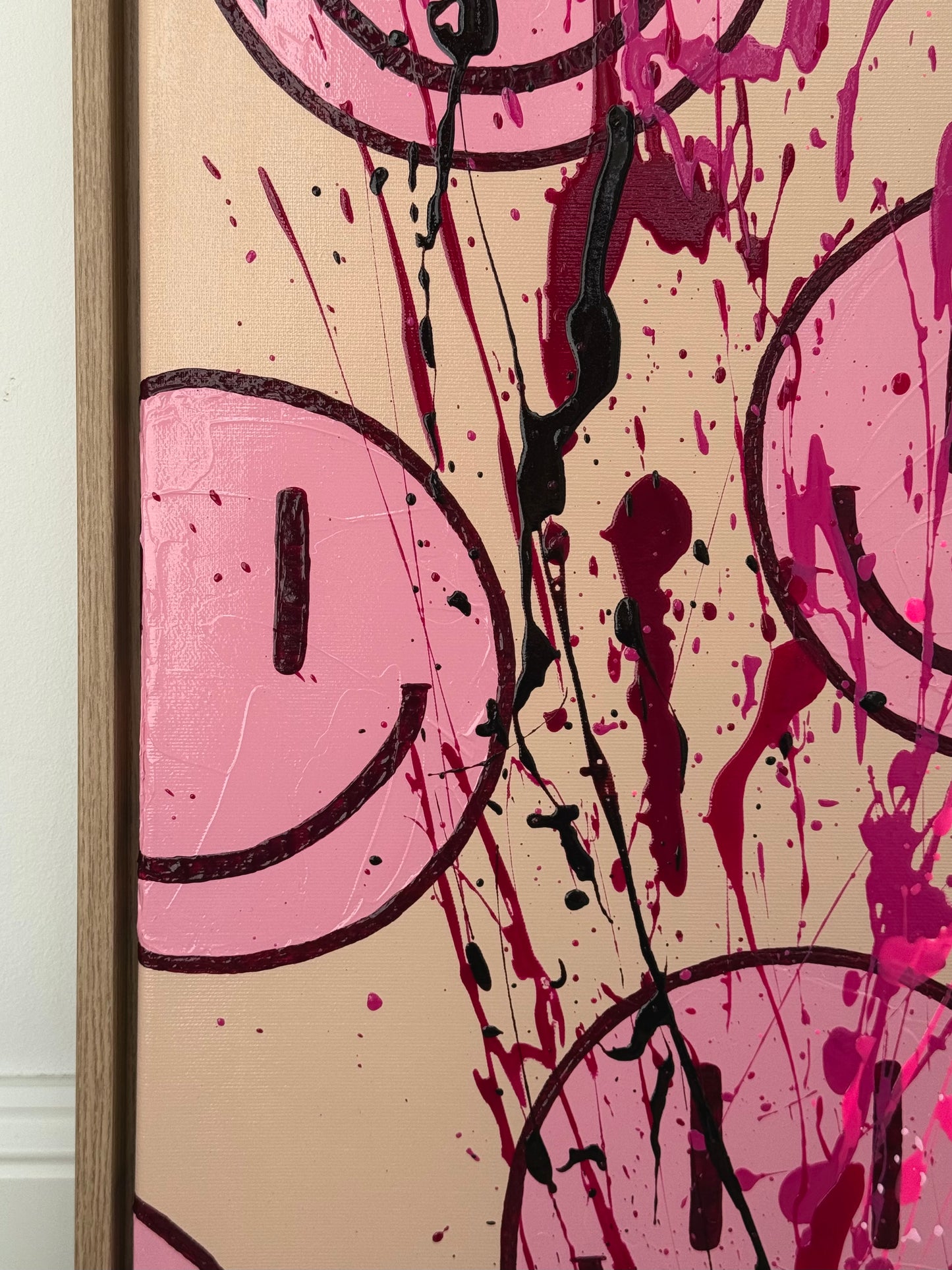 Nahaufnahme Happy-Face Kunstwerk mit Farbspritzern in Pink und Dunkelrot, strukturreiche Oberfläche und Mixed Media