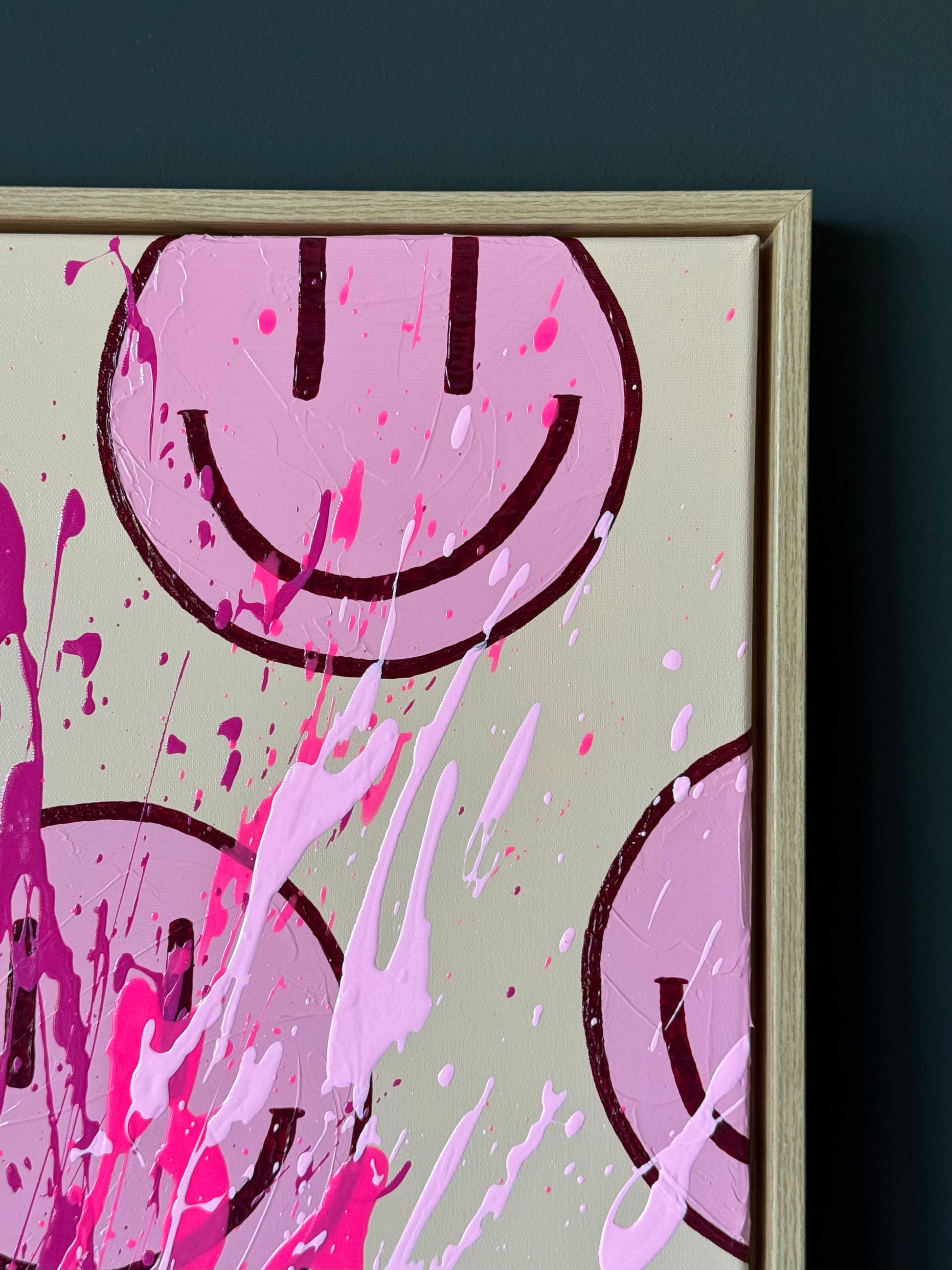 Close-up modernes Acrylbild mit Smiley Motiv, Farbspritzer in Pink und Dunkelrot, strukturierte Oberfläche sichtbar