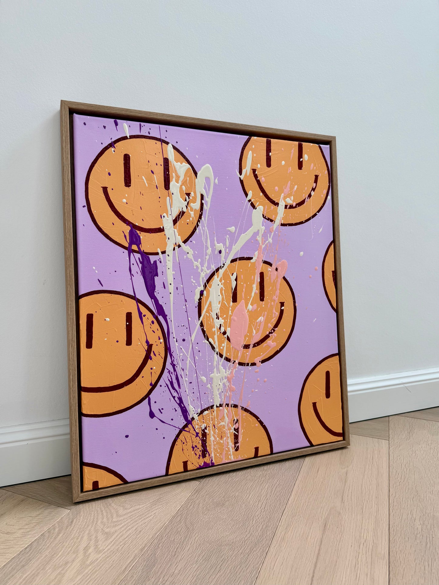 HAPPY #16, abstraktes Happy-Face-Acrylbild in Flieder und Orange mit Eichenrahmen, handgemaltes Original auf Leinwand auf hellem Holzboden angelehnt.