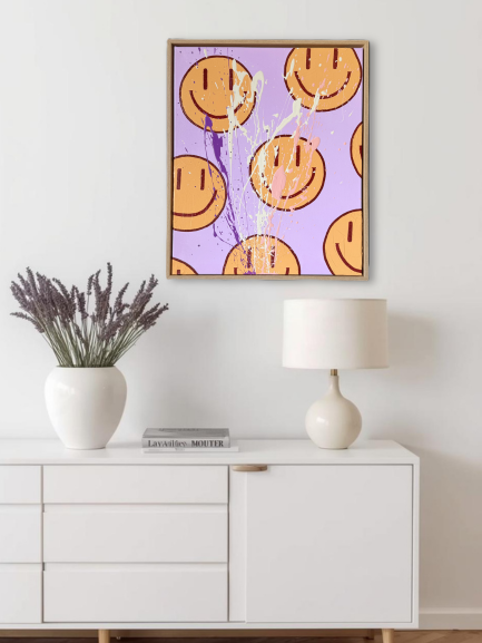 HAPPY #16 als modernes Smiley Acrylbild über einer Kommode, abstrakte Wandkunst in Flieder und Orange für stilvolle Wohnräume.