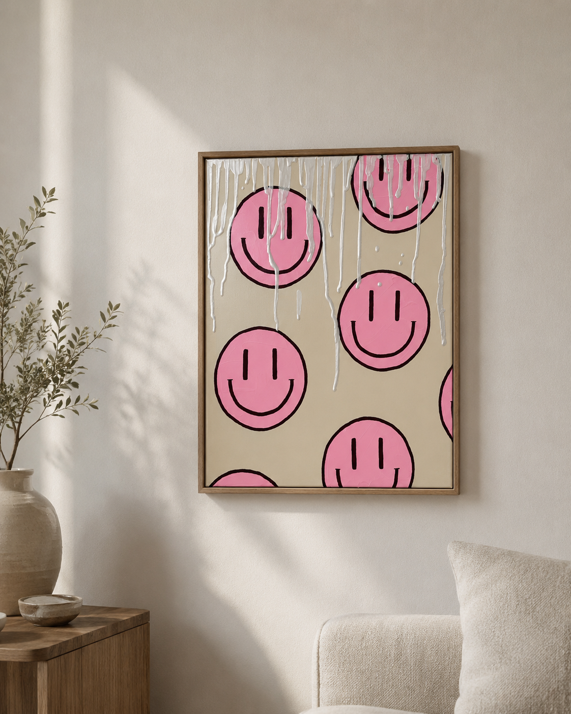 Handgemaltes Acrylgemälde der HAPPY-Serie mit rosa Happy-Faces auf beigem Hintergrund, weißer Struktur und Holzrahmen in einem hellen Wohnraum.