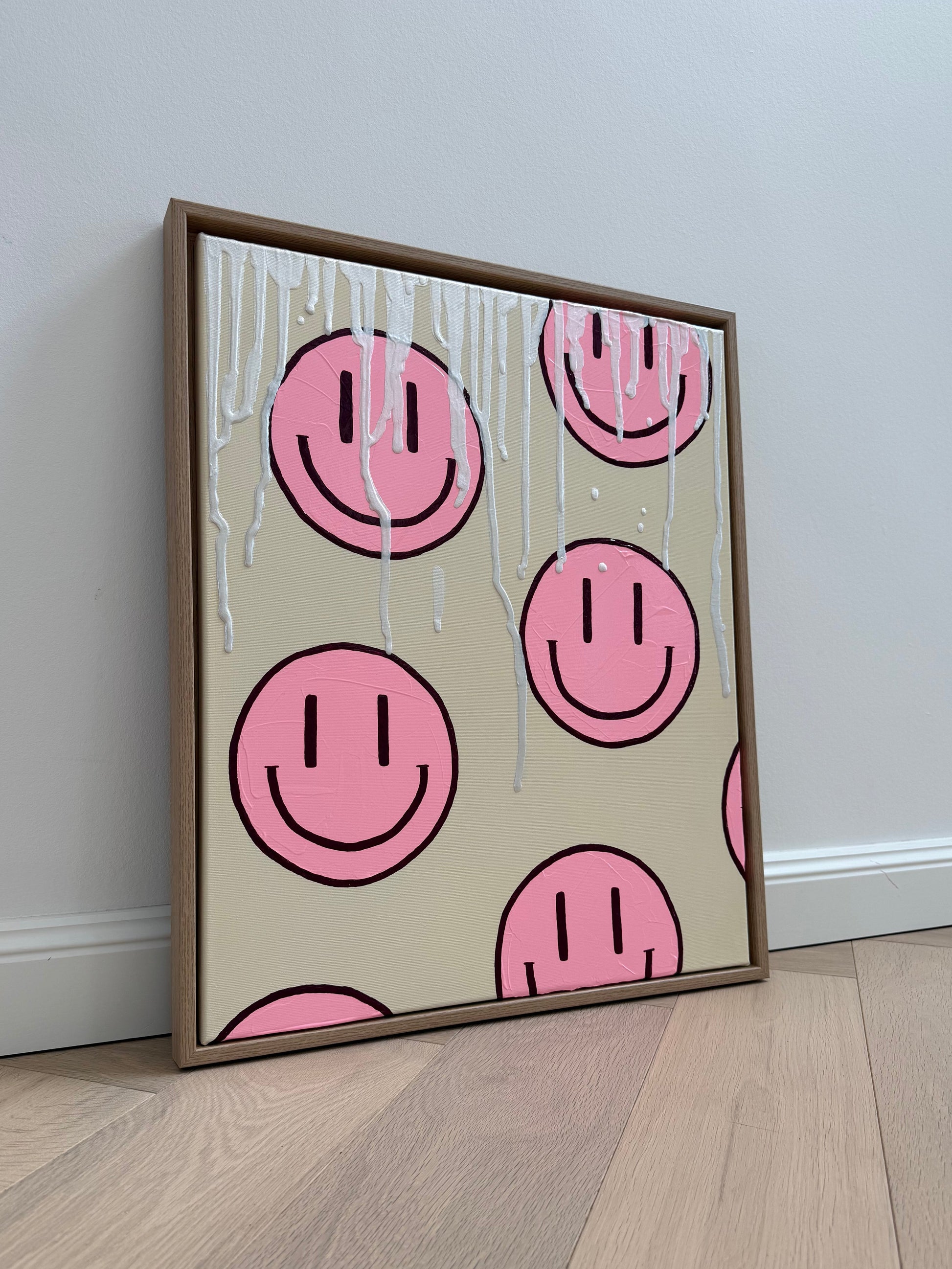 Abstraktes Acrylgemälde mit rosa Happy-Faces auf strukturierter Leinwand, modern gerahmt in Holzoptik für ein farbenfrohes Interior.