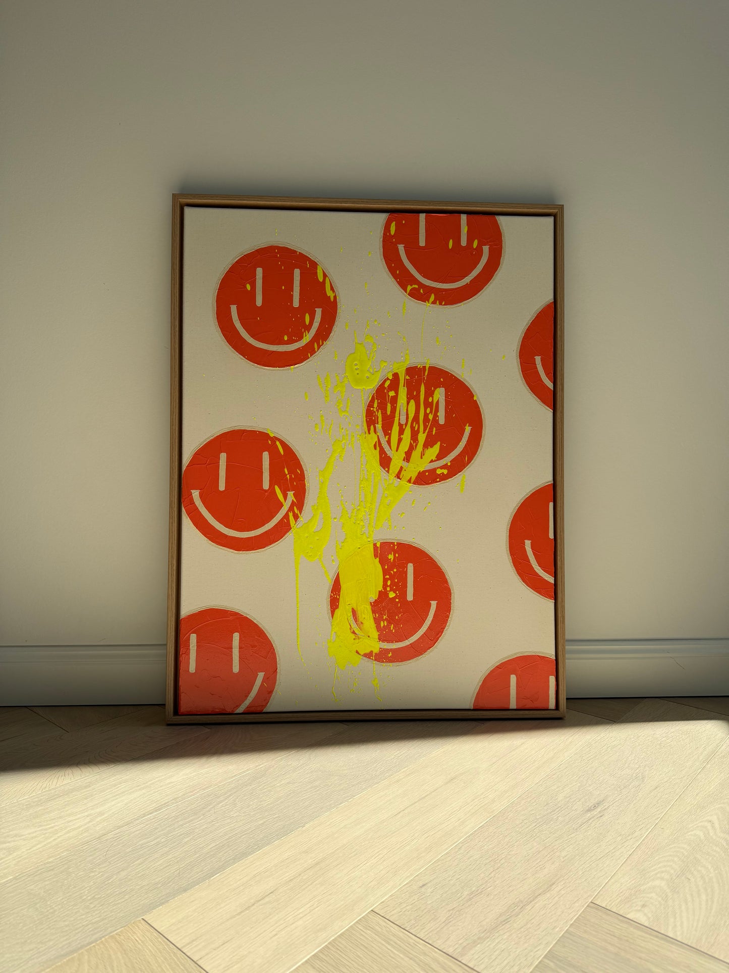 HAPPY #18 in warmem Licht fotografiert, modernes Happy-Face Kunstwerk mit orangenen Motiven und neongelbem Farbspritzer
