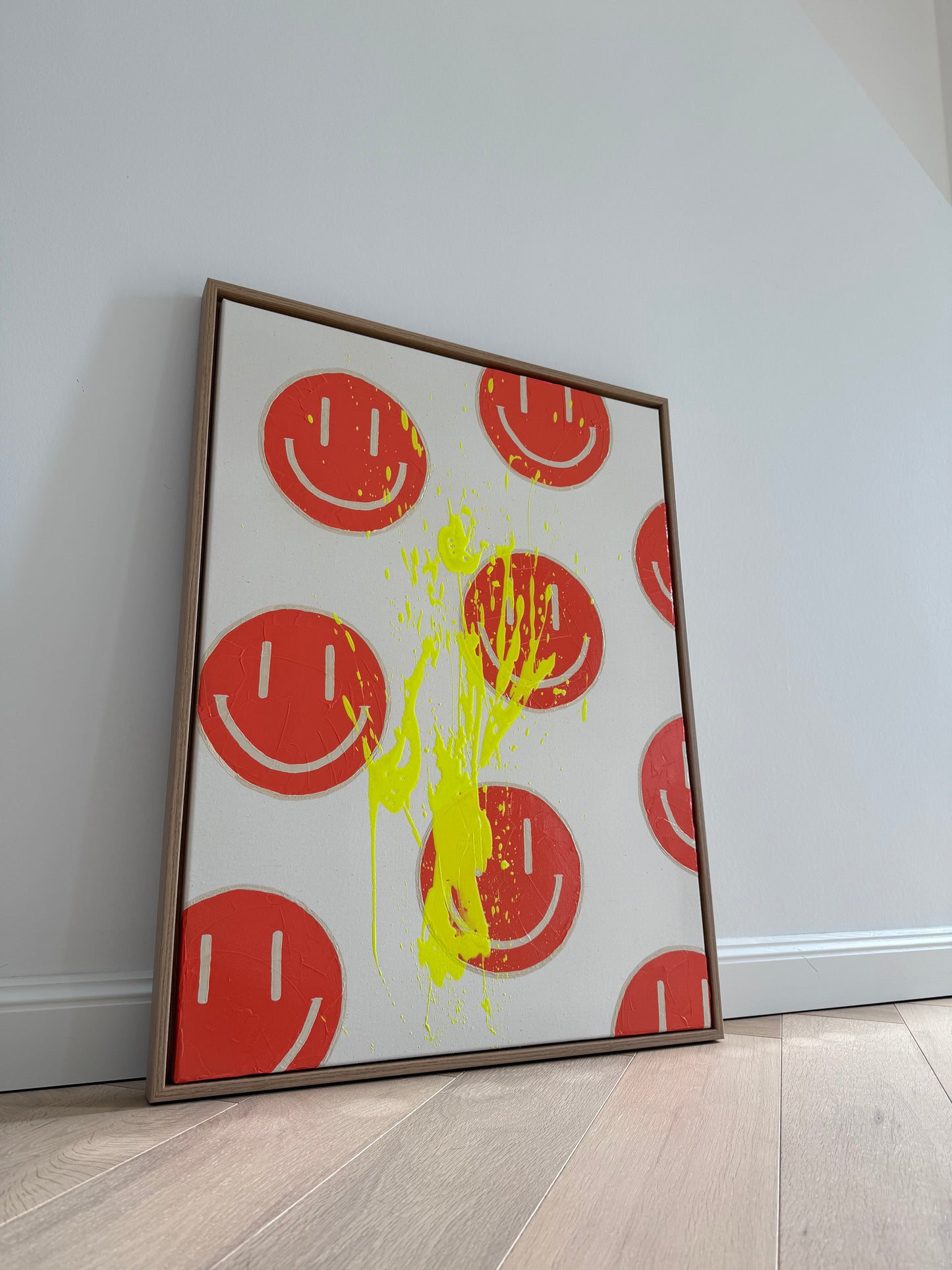 HAPPY #18 an heller Wand fotografiert, abstraktes Acrylbild in Orange und Neongelb auf roher Leinwand im Eichenrahmen