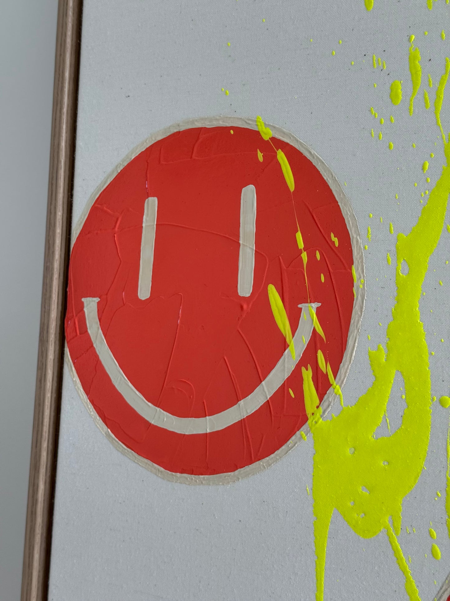 Detailaufnahme von HAPPY #18 mit orangenen Happy-Faces, hellbeigen Details und neongelbem Farbspritzer auf roher Leinwand