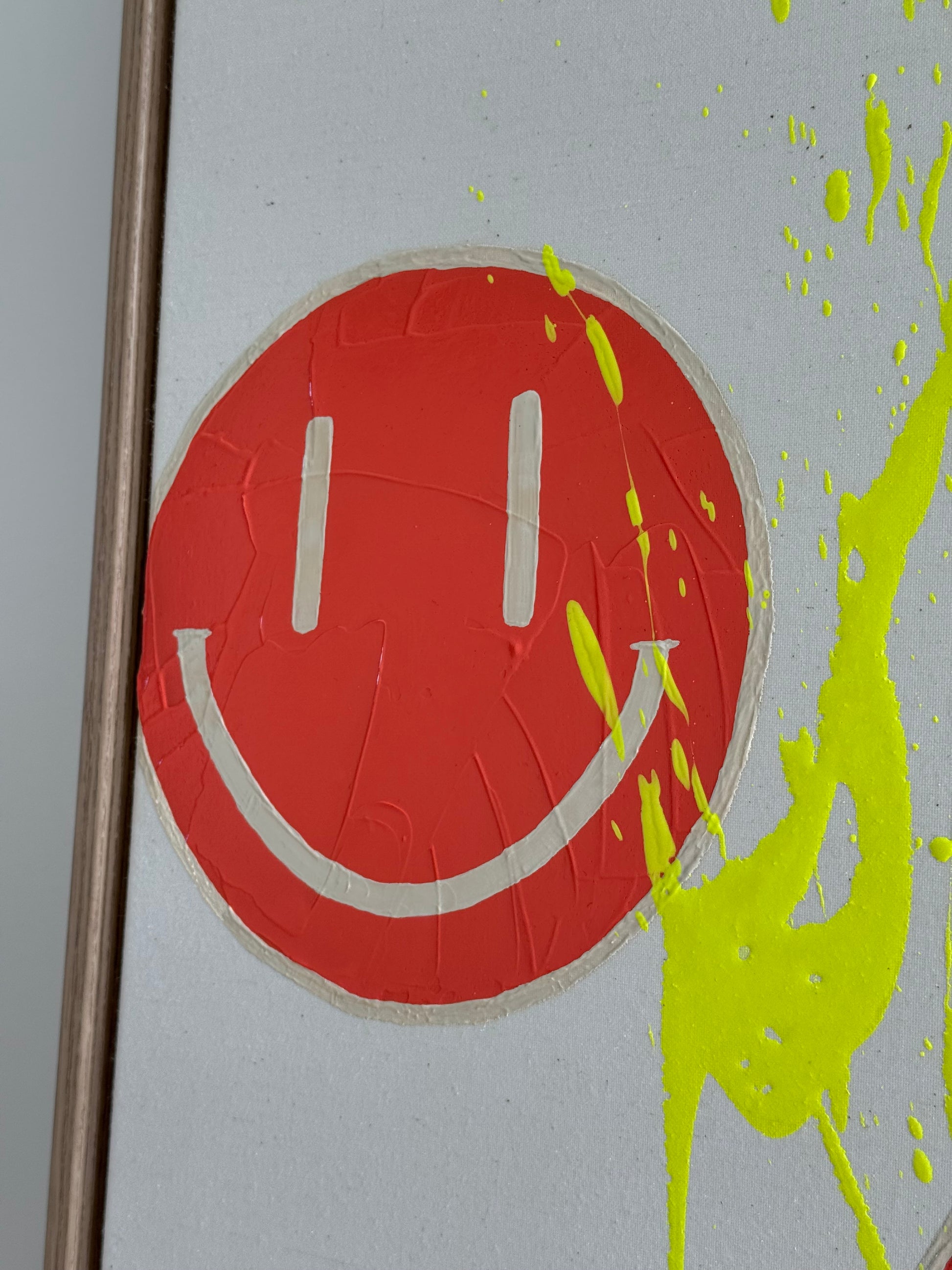 Detailaufnahme von HAPPY #18 mit orangenen Happy-Faces, hellbeigen Details und neongelbem Farbspritzer auf roher Leinwand