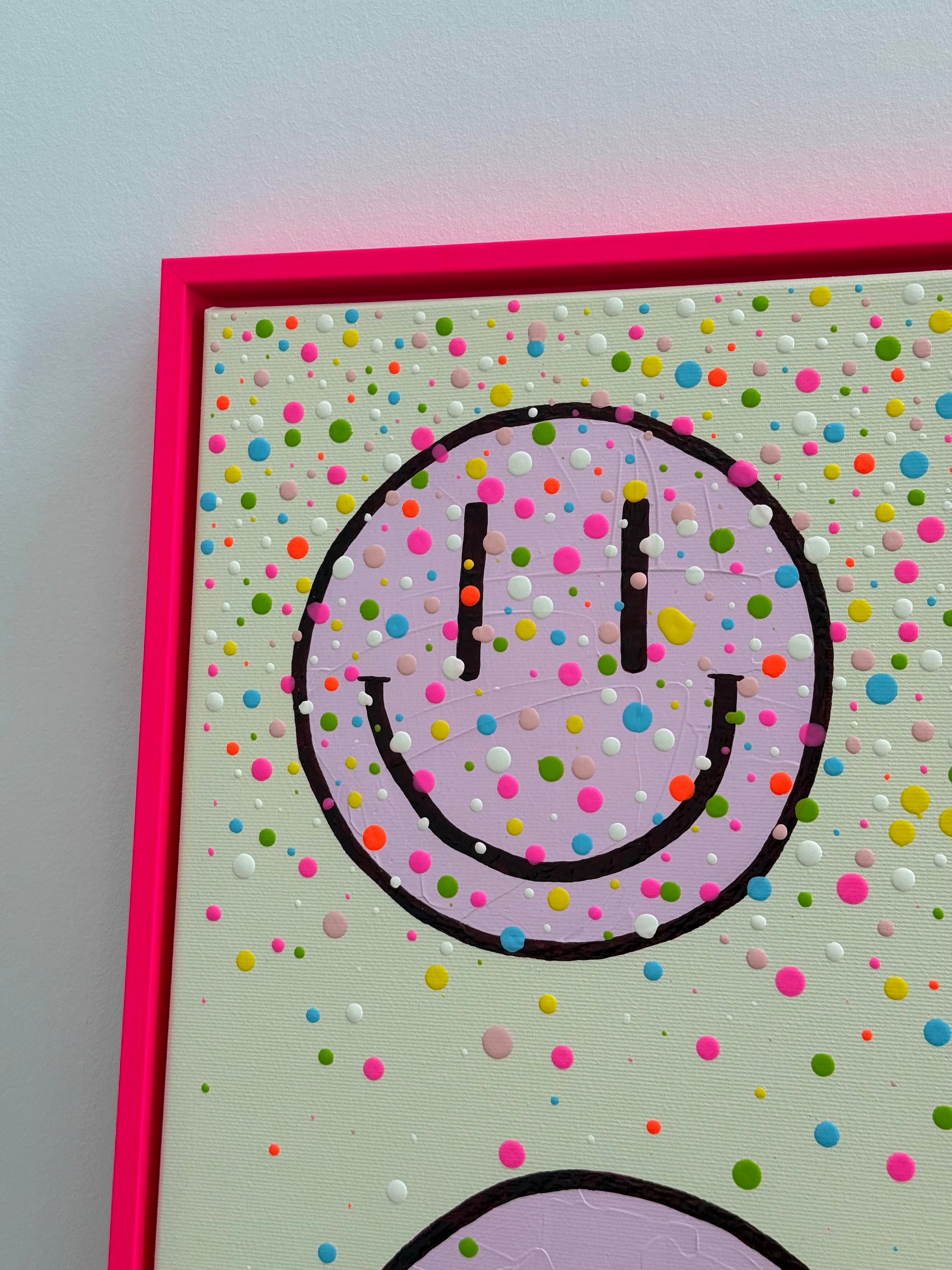 Detail von HAPPY #26 mit angeschnittenem hellrosa Happy Face, bunten erhabenen Farbtropfen und neonpinkem Schattenfugenrahmen.