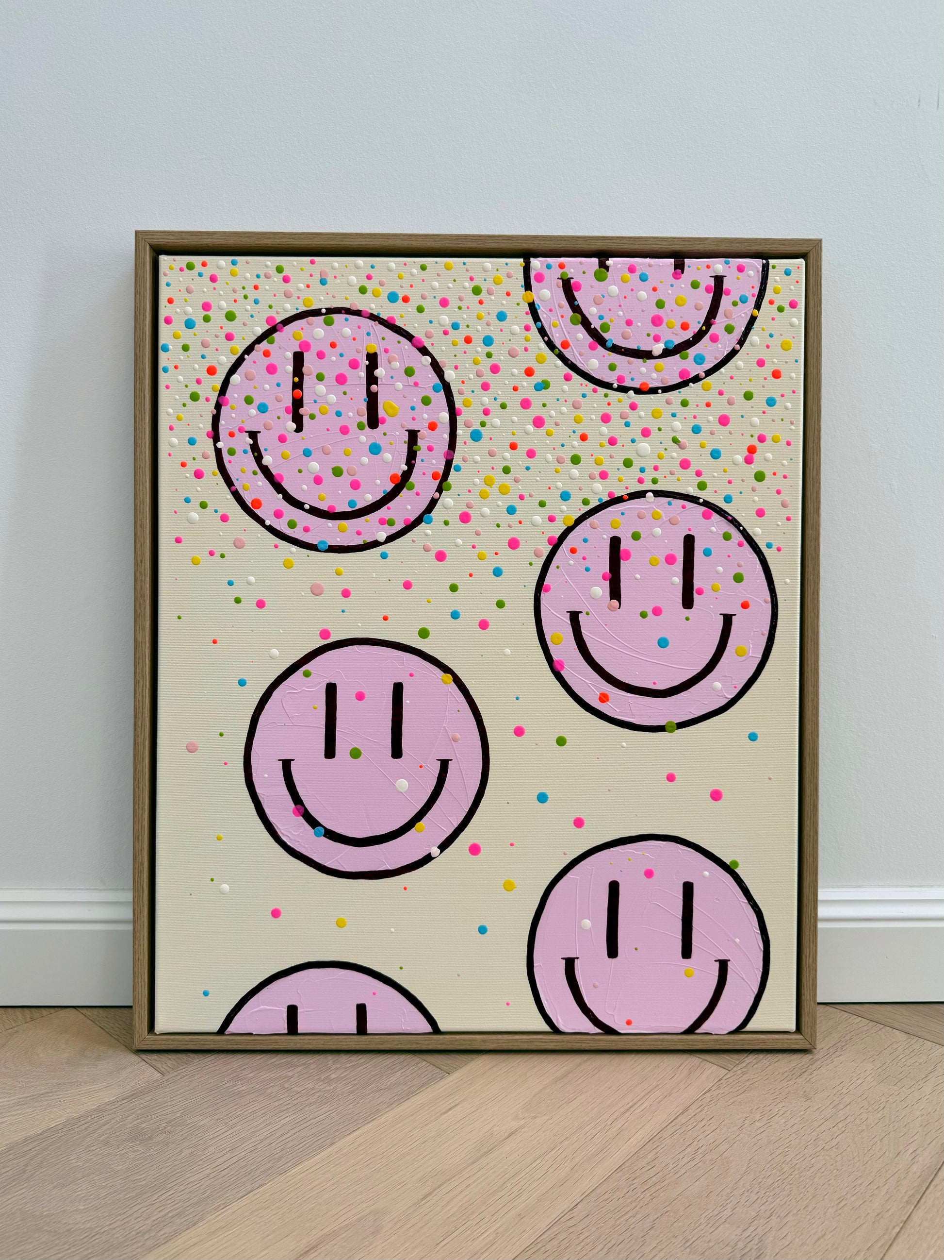 Frontalansicht des handgemalten Kunstwerks HAPPY #26 mit sechs angeschnittenen und vollständigen Happy Faces im Schattenfugenrahmen aus Eiche Natur.