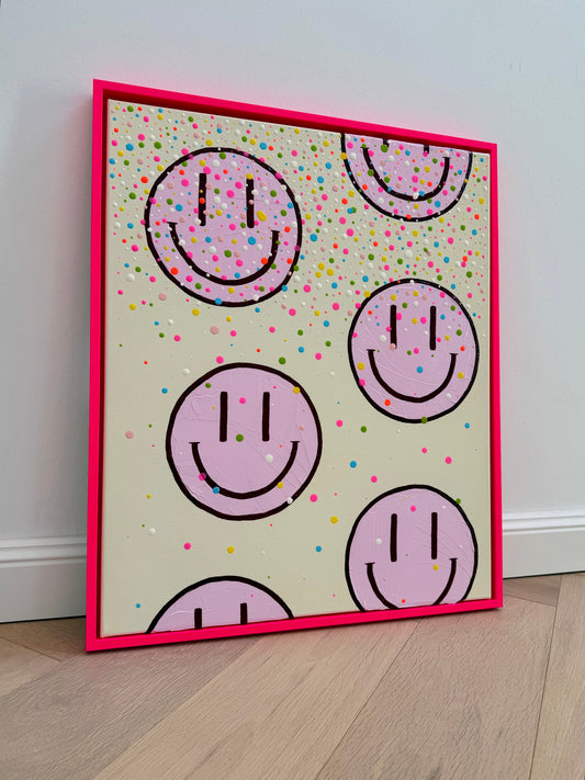 Vollansicht des handgemalten Acrylbildes HAPPY #26 mit hellrosa Happy Faces und bunten Farbtropfen im neonpinken Schattenfugenrahmen.