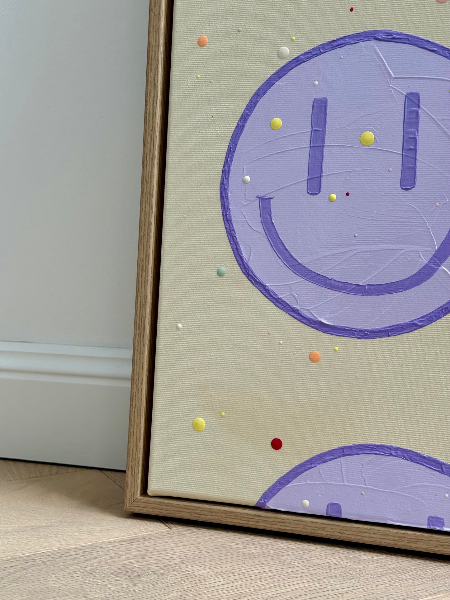Detailansicht der Komposition von HAPPY #27 mit angeschnittenen Happy-Faces und unterschiedlich großen, erhabenen Farbpunkten auf beigem Hintergrund.