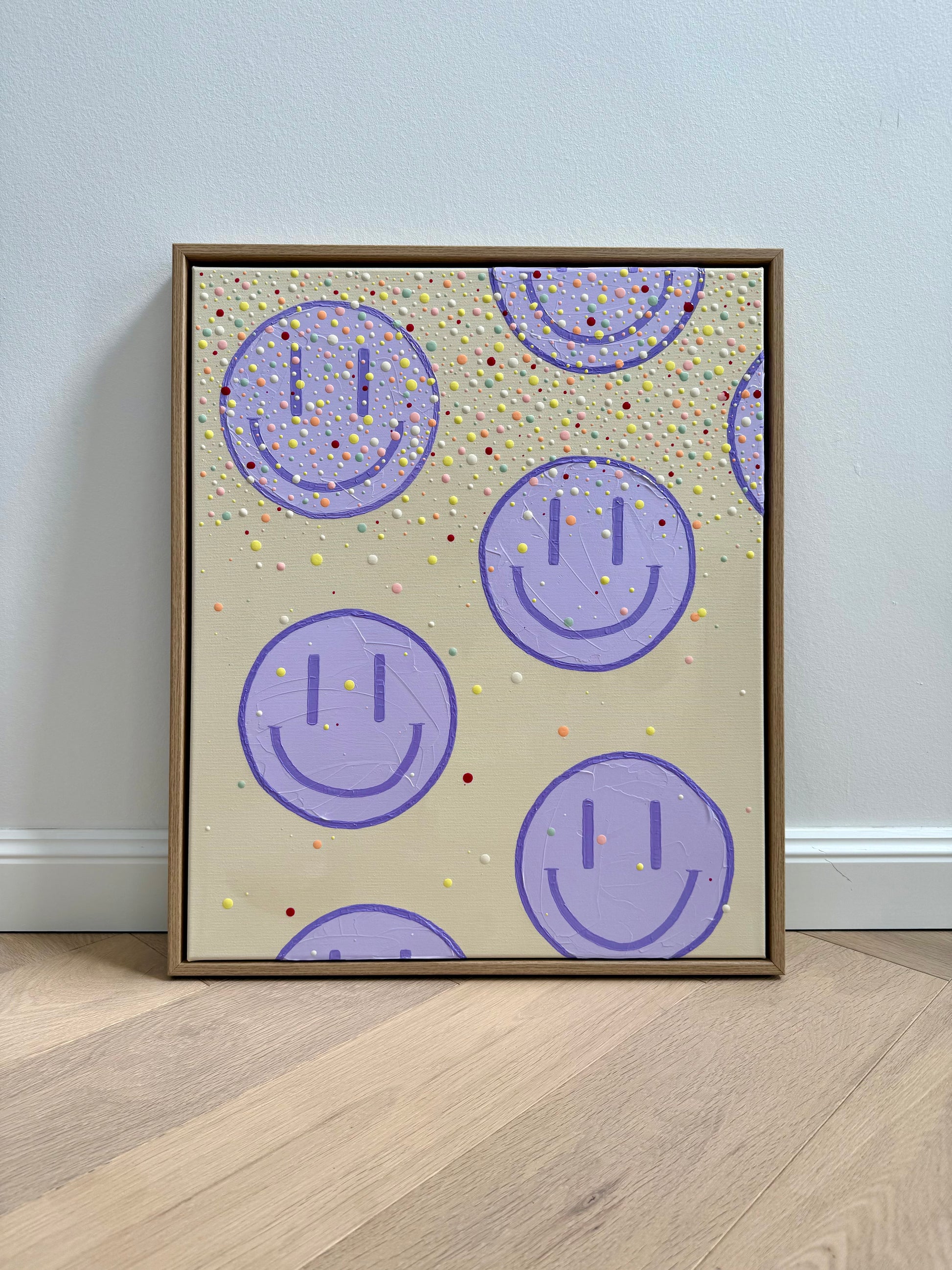 Gesamtansicht des gerahmten Acrylbildes HAPPY #27 mit fliederfarbenen Happy-Faces und Farbpunkten in Hell-Zitronengelb, Apricot, Rosa, Salbei, Offwhite und Beere.