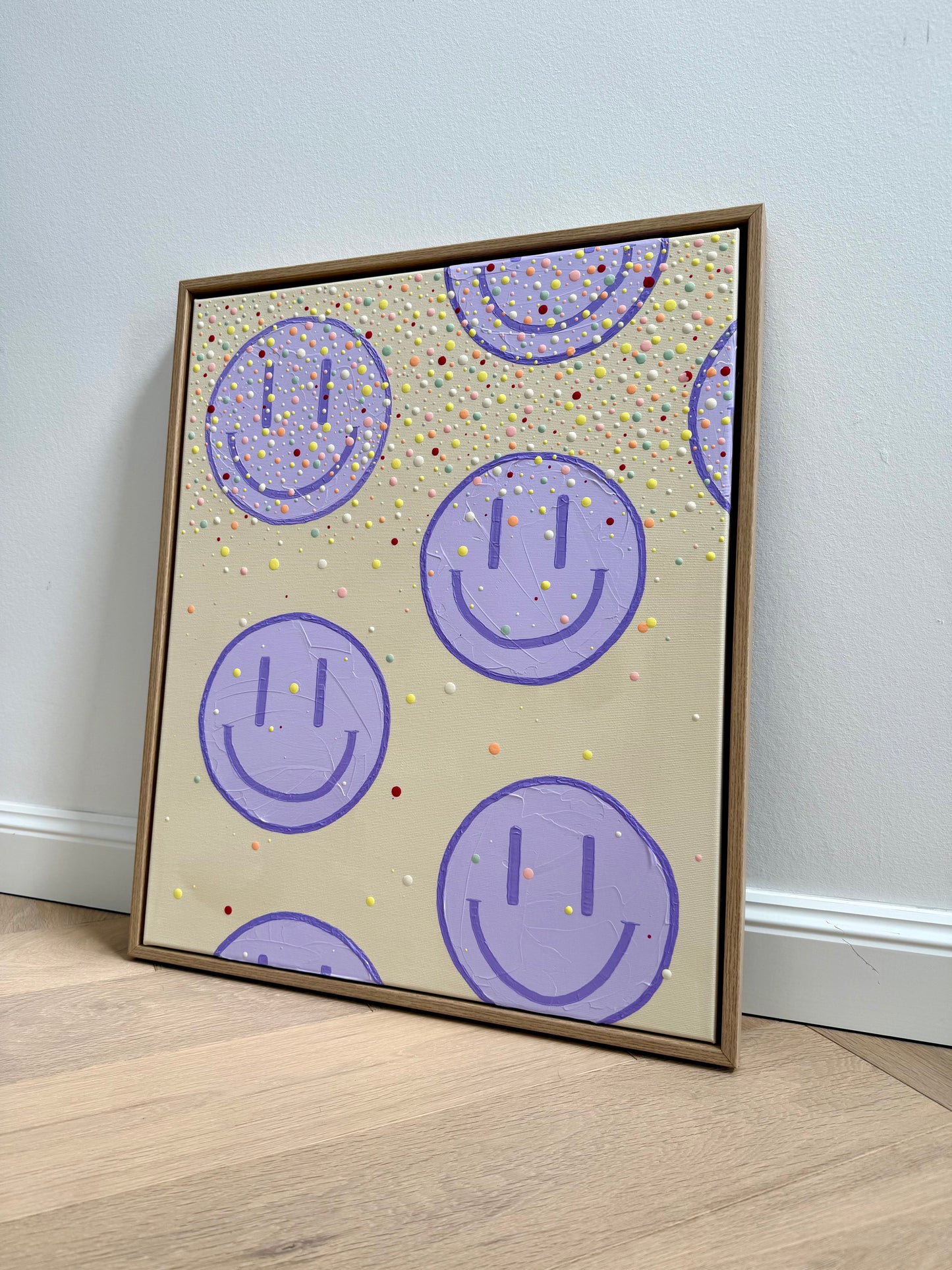 Gesamtansicht des 50 × 60 cm großen Acrylbildes HAPPY #27 mit fliederfarbenen Happy-Faces, bunten Farbpunkten und Eichen-Schattenfugenrahmen.