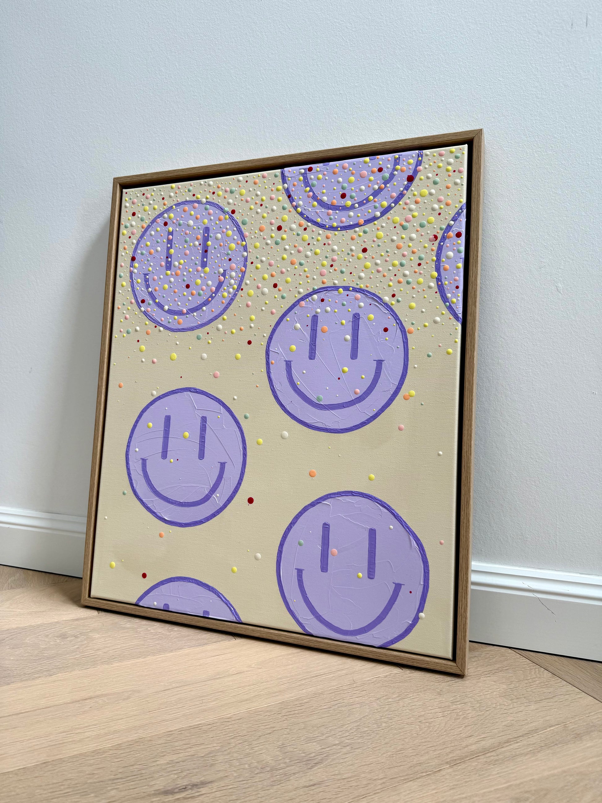 Gesamtansicht des 50 × 60 cm großen Acrylbildes HAPPY #27 mit fliederfarbenen Happy-Faces, bunten Farbpunkten und Eichen-Schattenfugenrahmen.