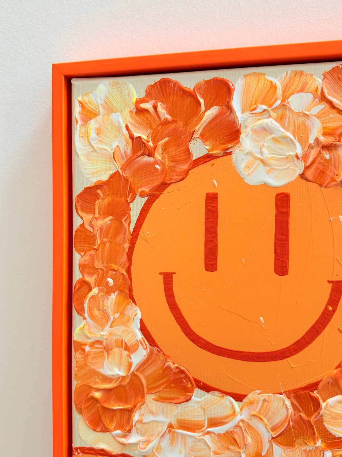 Obere linke Ecke von HAPPY #30 mit pastellorangefarbenem Happy Face, umgebenden Blüten in Mandarinenorange und Creme sowie orangefarbenem Schattenfugenrahmen.